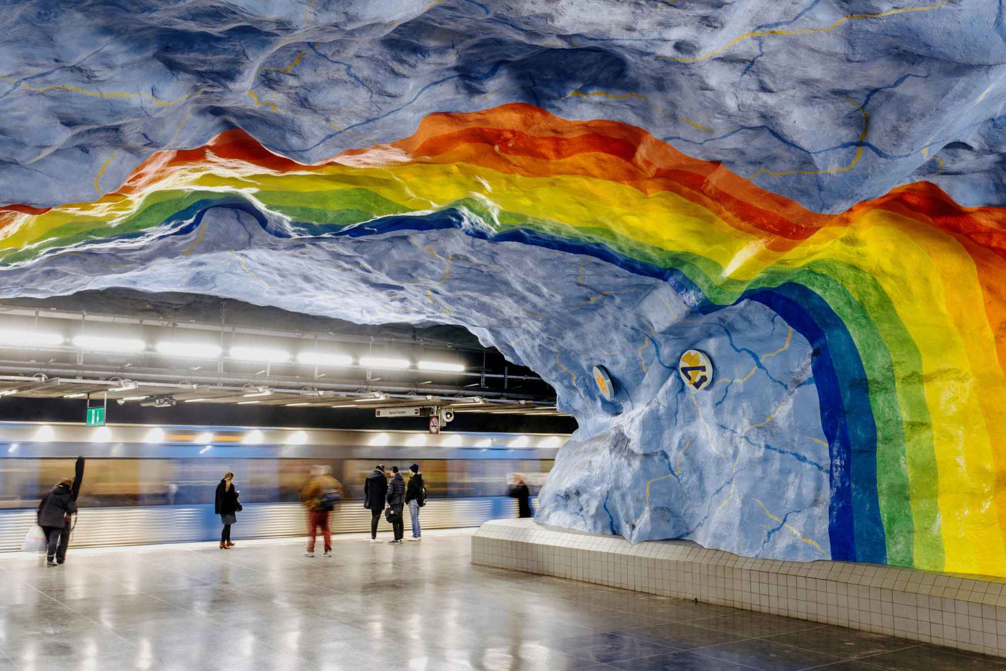 A rainbow in vivid colors painted in the ceiling in a subway station.