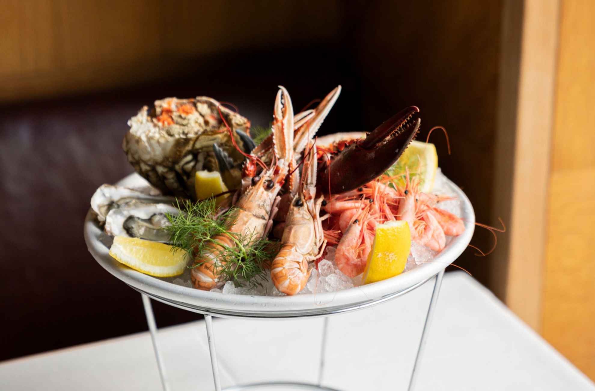 Fresh crayfish, oysters, shrimp, crab, lemon, and dill on a seafood platter at restaurant Sturehof.
