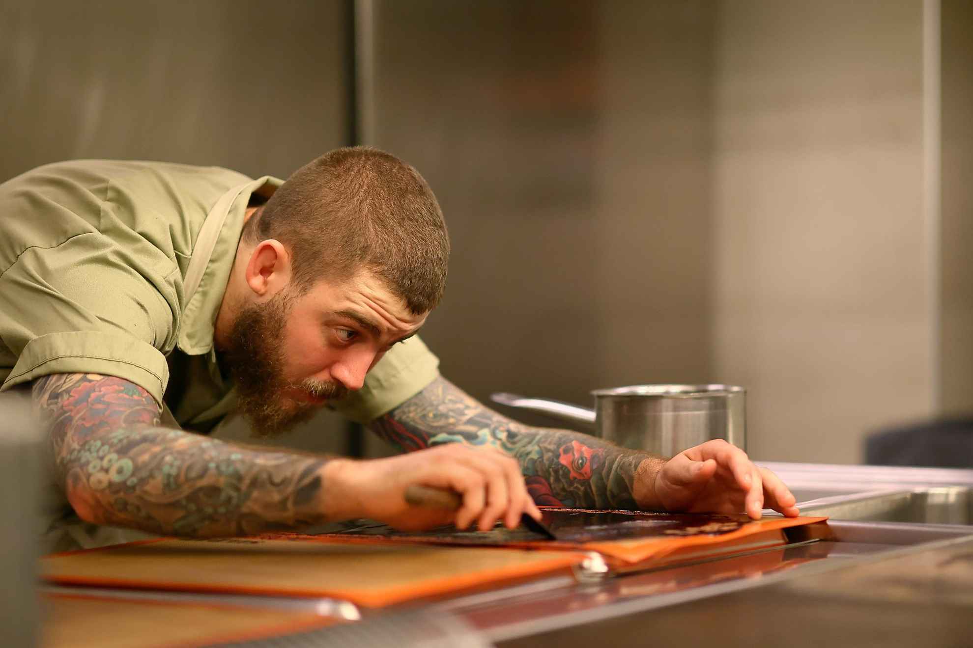 A chef looks concentrated preparing food.