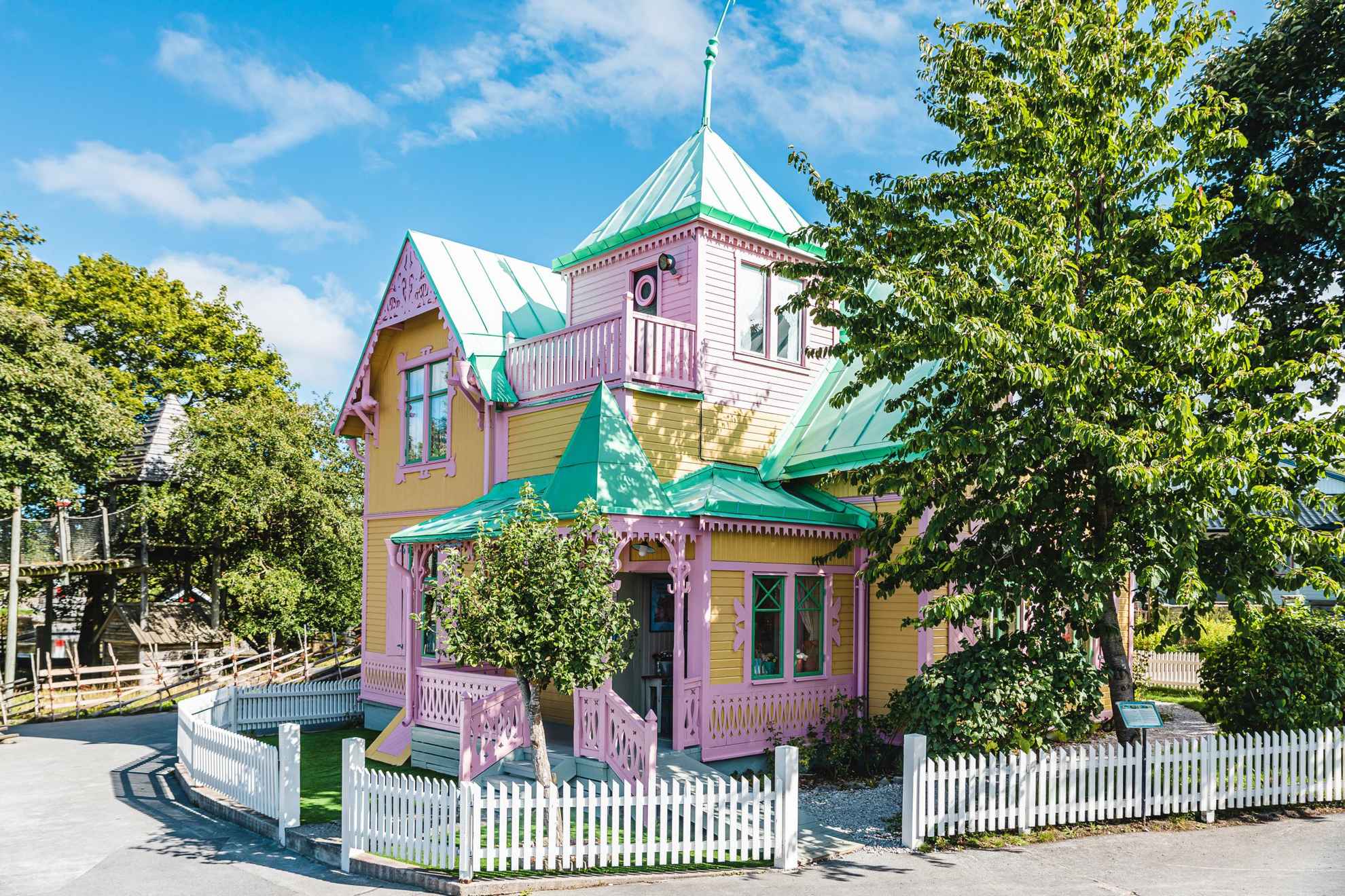 A yellow wooden house with pink trims based of the book from Pippi Longstocking.