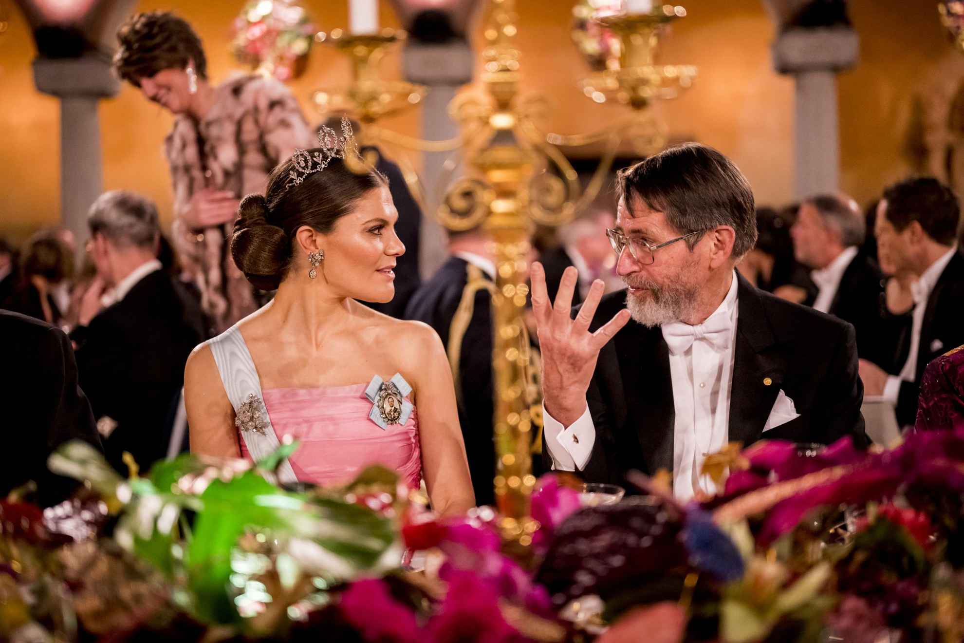 Crown Princess Victoria has a conversation with the man sitting next to her during the Nobel banquet.