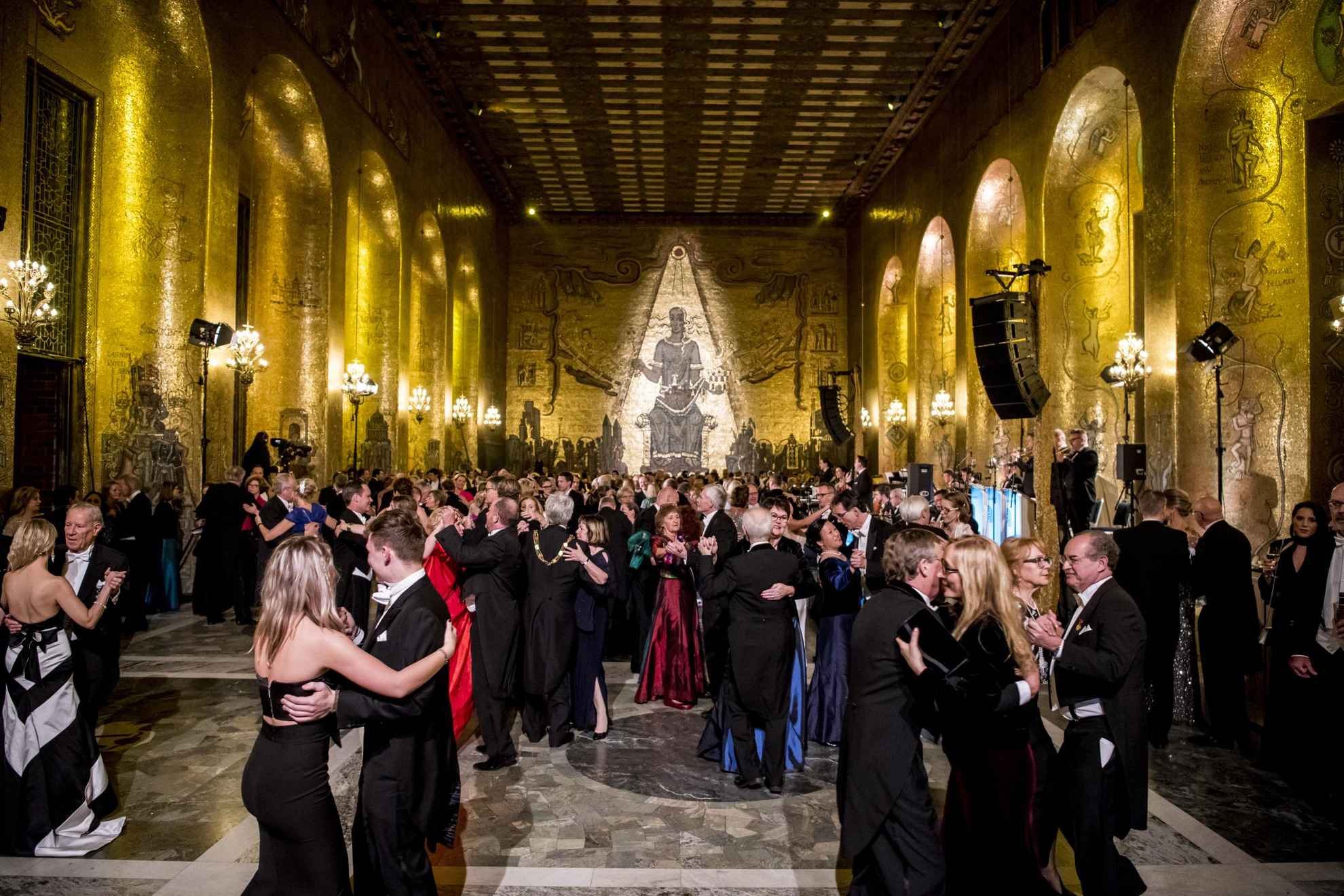 People dancing in a golden hall.