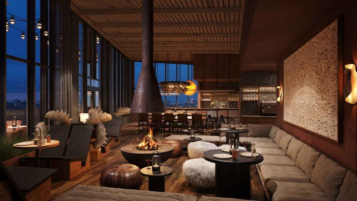 Cozy lounge at Elite Hotel Frost in Kiruna, featuring an open fireplace and sofas, warmly lit in the evening.