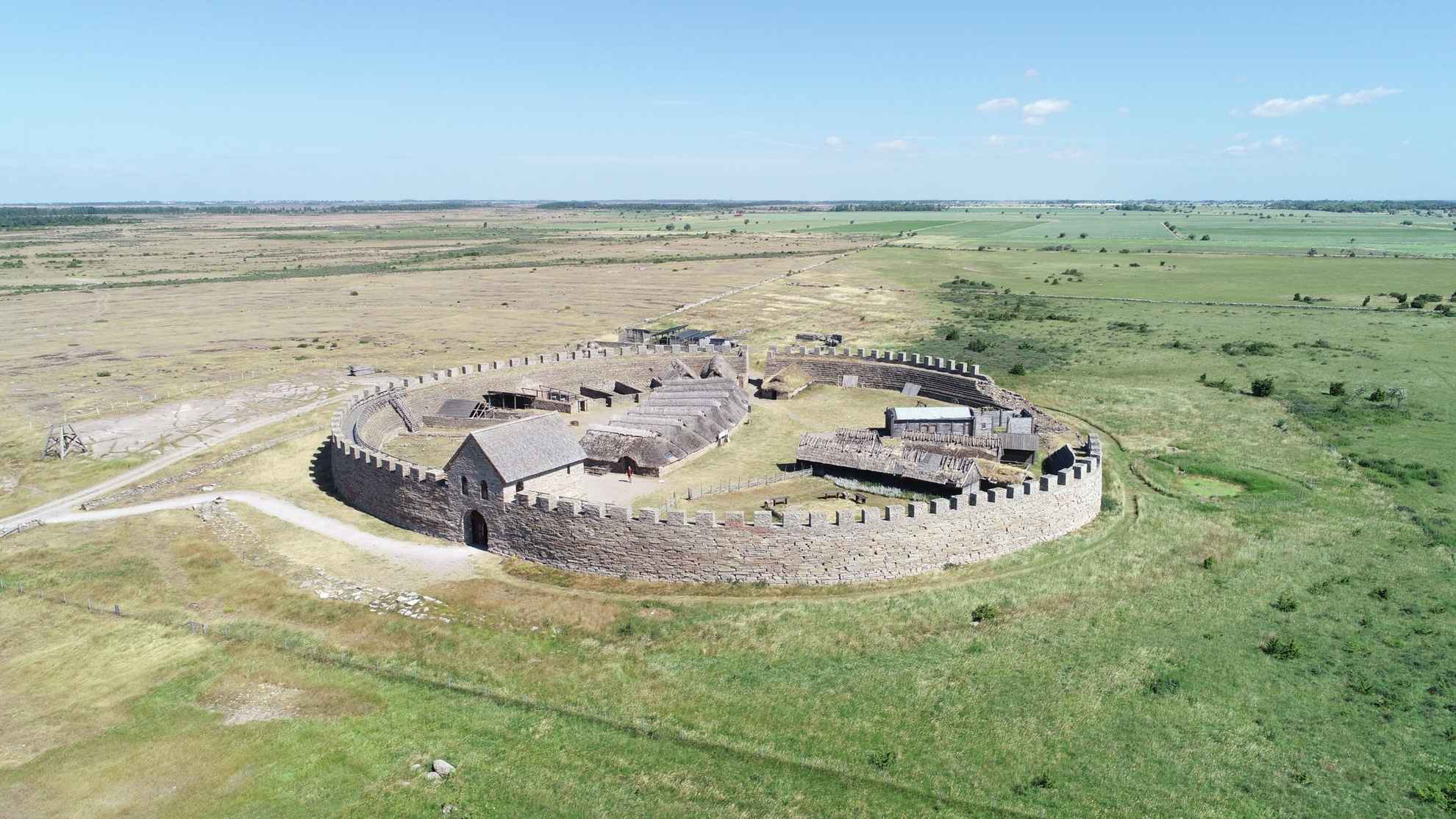An round stone fortress surrounded by vast fields.