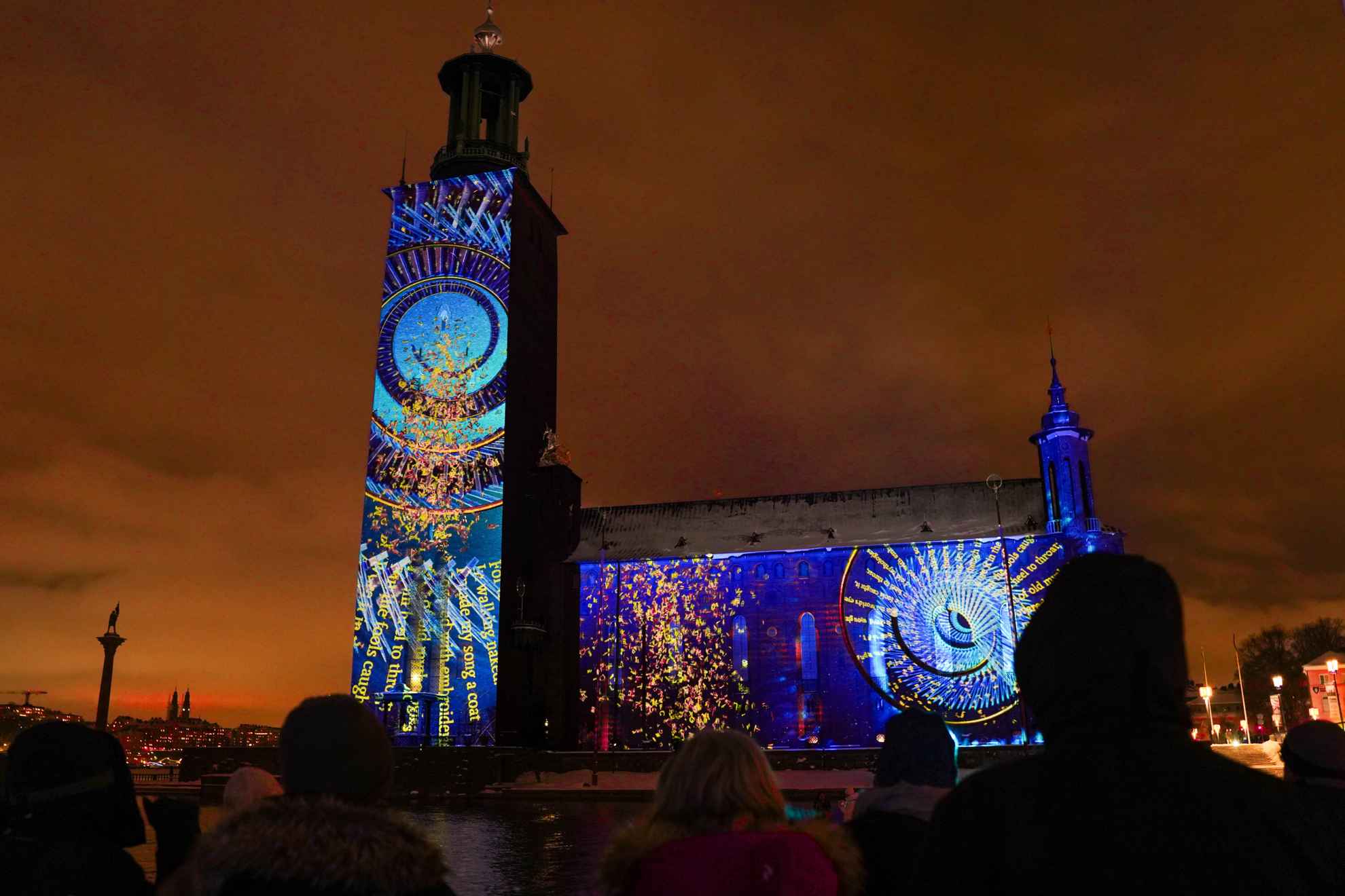 A light installation projecting colorful patterns and historical events on the City Hall in Stockholm, Sweden.