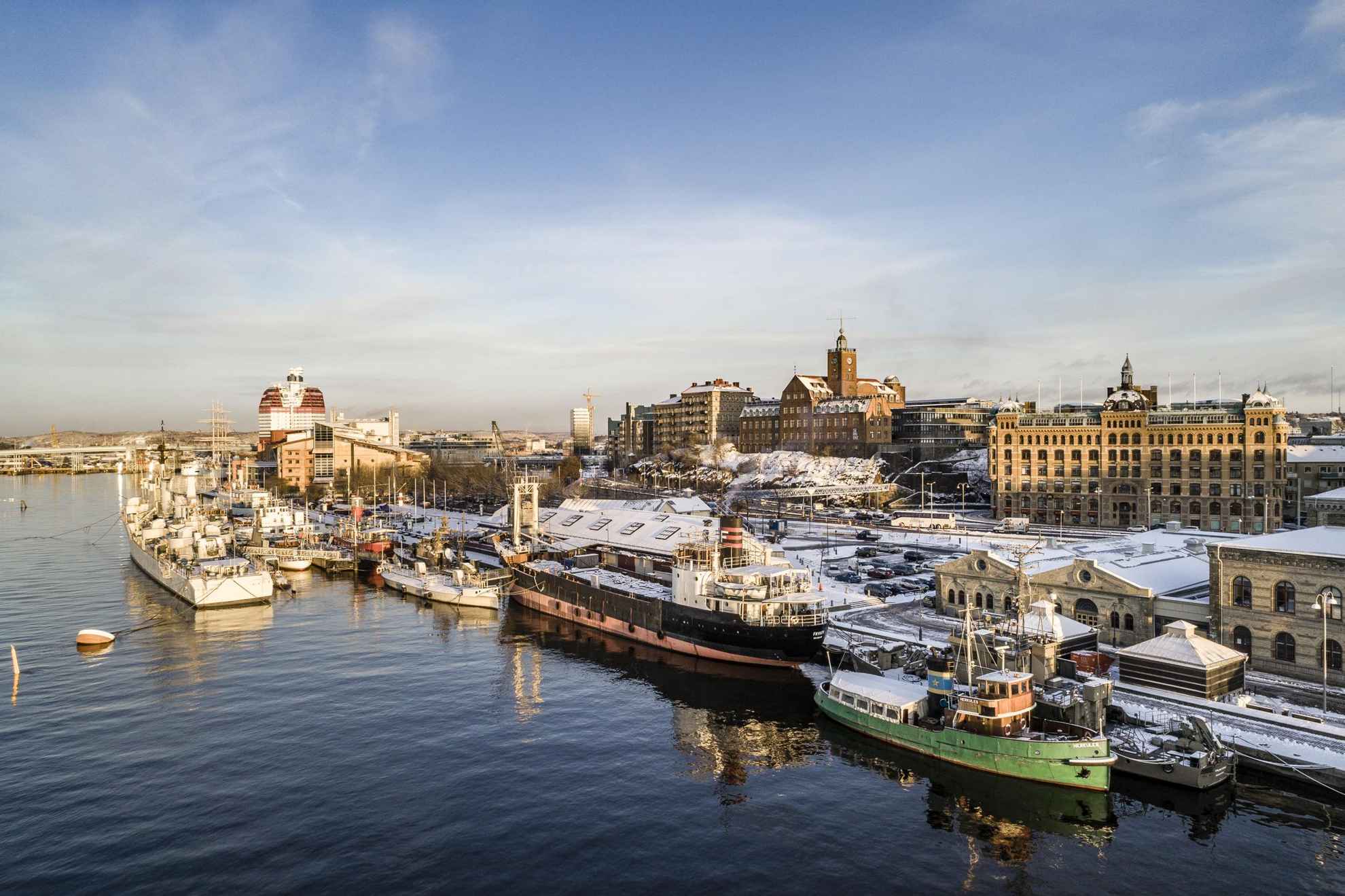 Boats and cargo ships in a harbor during winter.