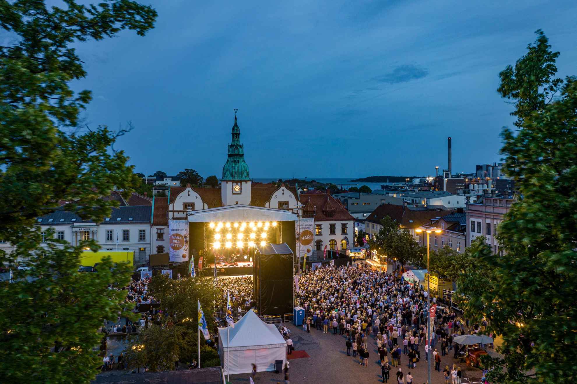 A festival area in a small city during a well-visited evening concert.