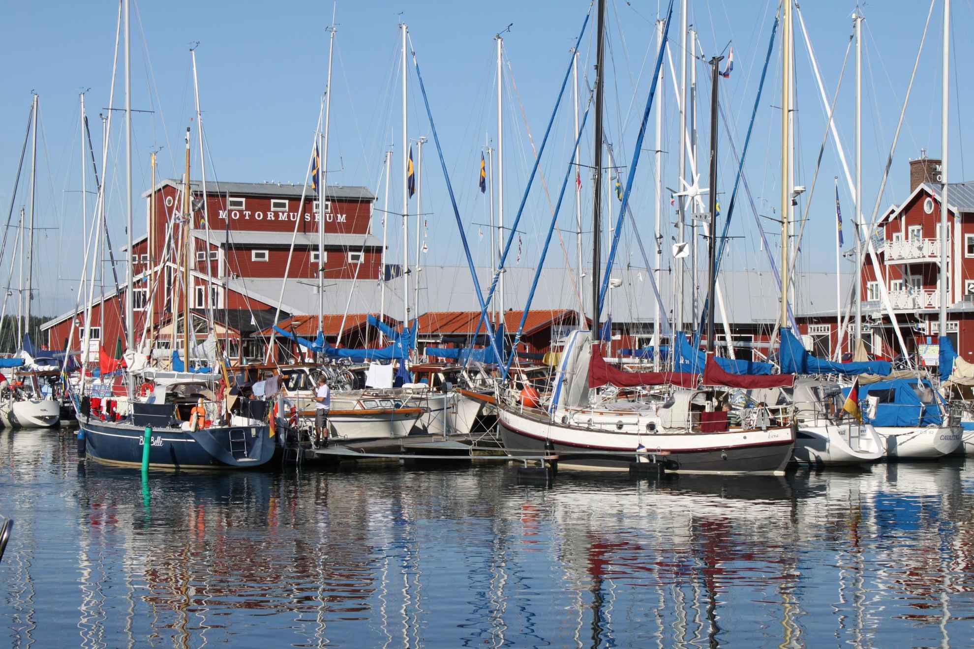 A harbor with several sailboats that are docked to a jetty.