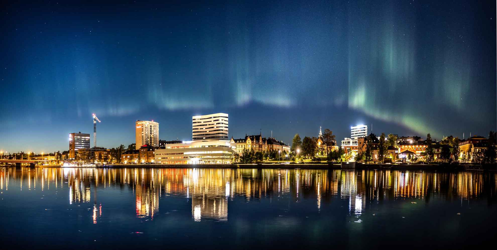 Northern lights over Umeå city skyline.
