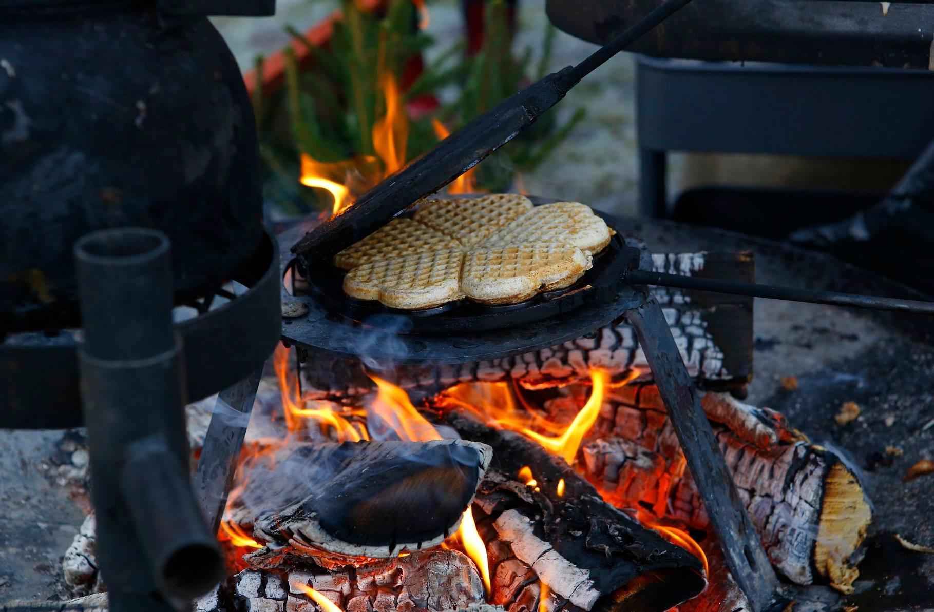 Close up on a waffle that bakes over open fire.