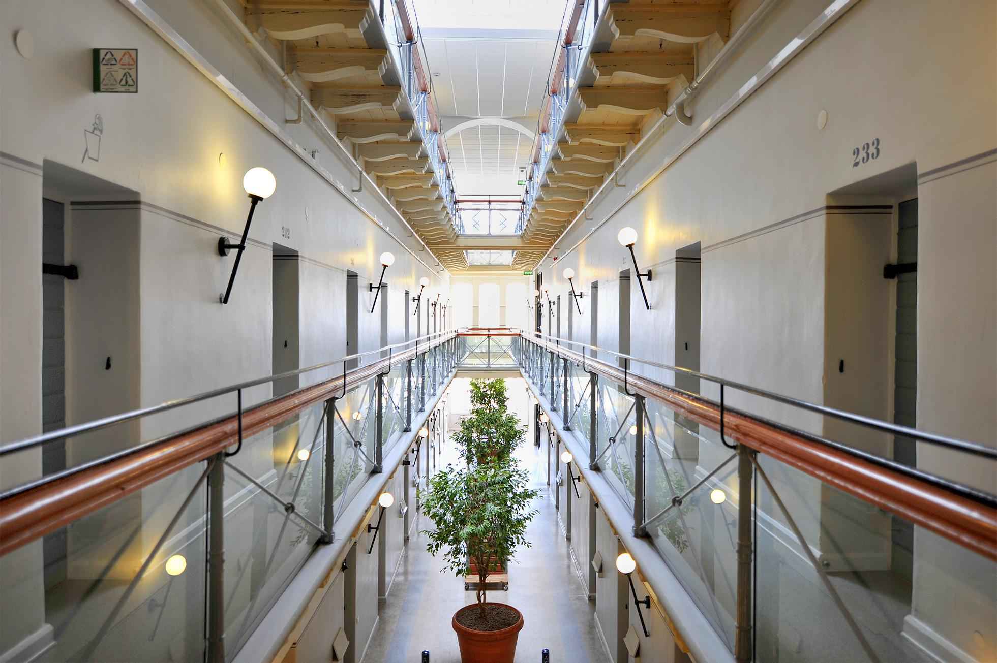 A long corridor with doors on each side, inside the STF Långholmen Vandrarhem which was once a prison.