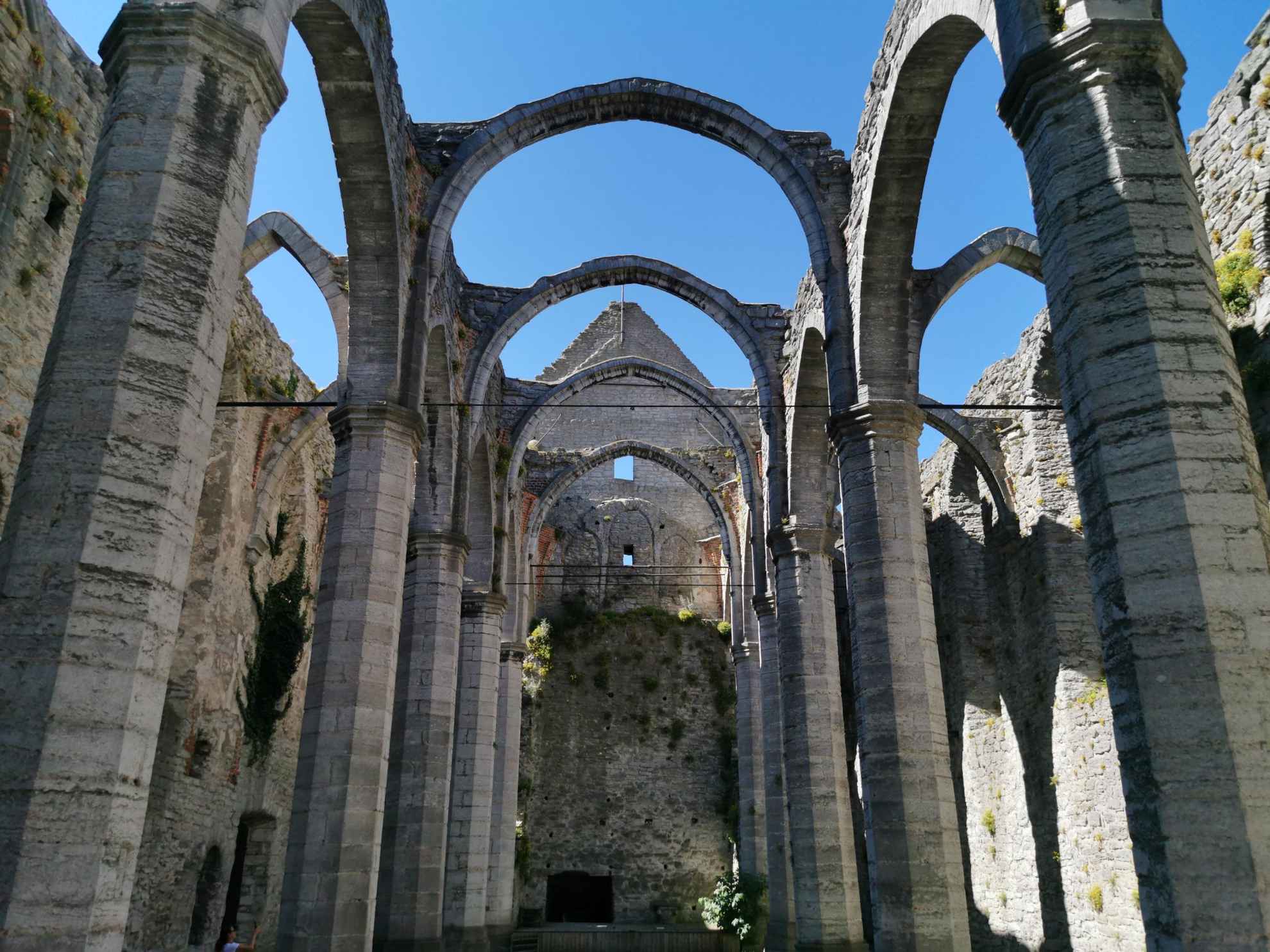 Inside a church ruin with high vaults without a ceiling.