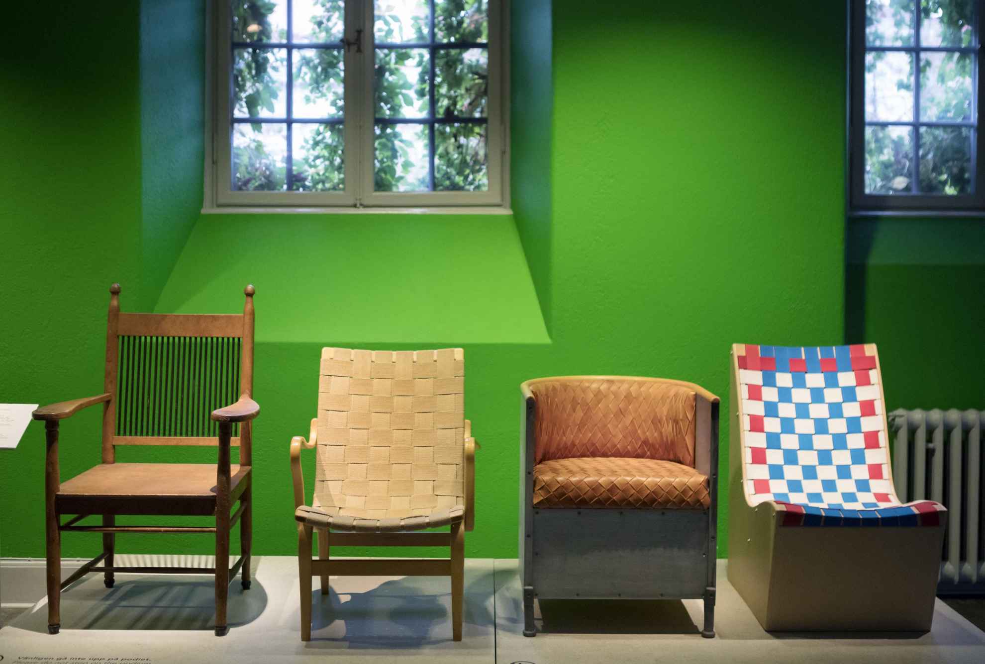 A exhibition showing four different chairs on a museum.
