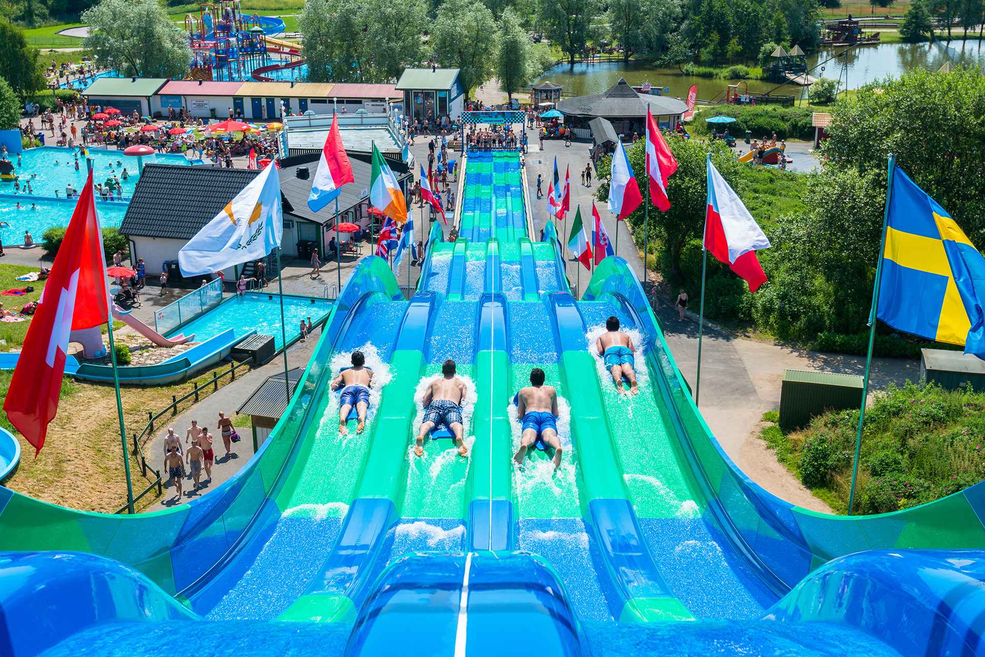 Four people riding in a long colourful waterslide with different lanes at Tosselilla
