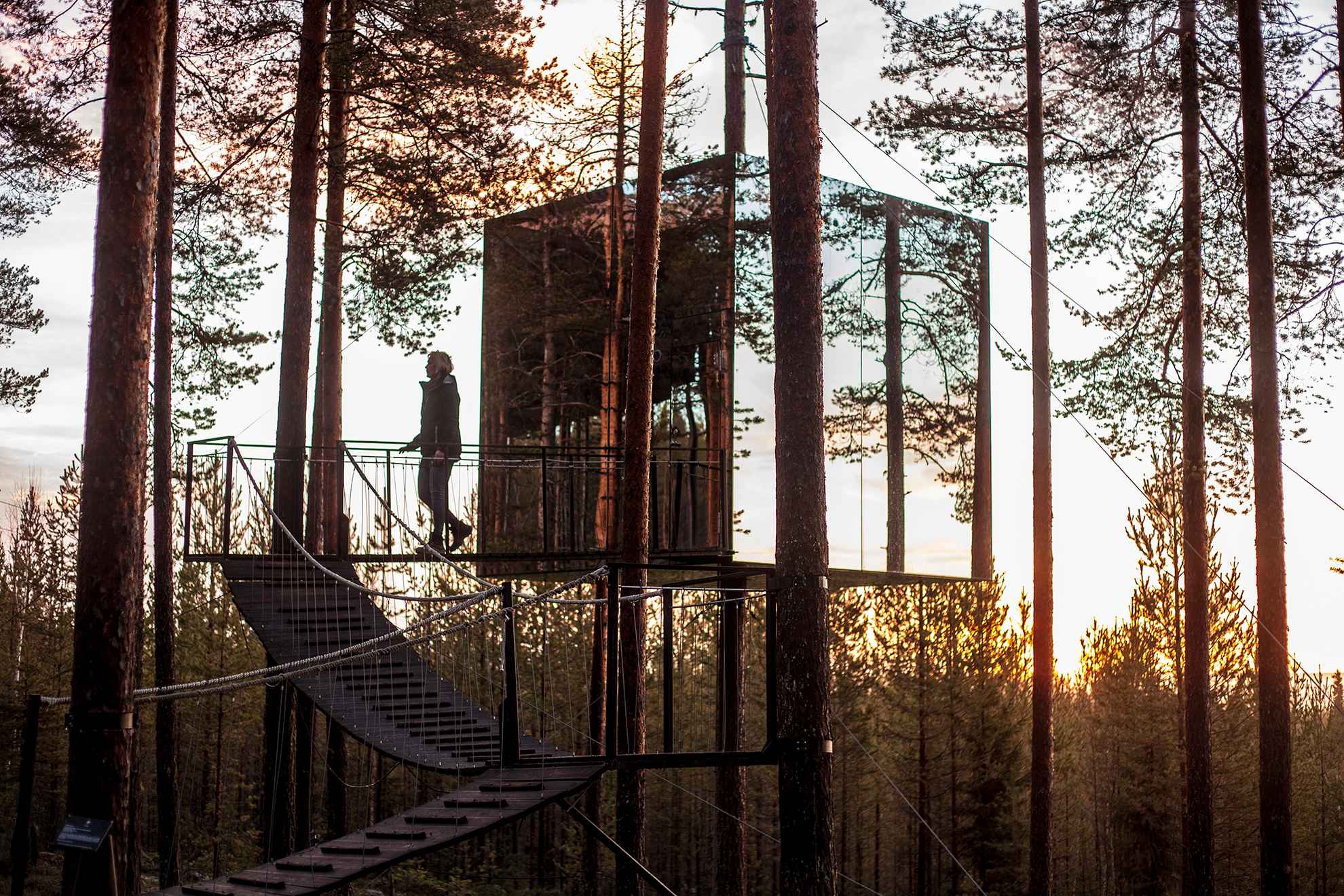 A tree hotel made of mirror glass, in the sunset in Swedish Lapland.