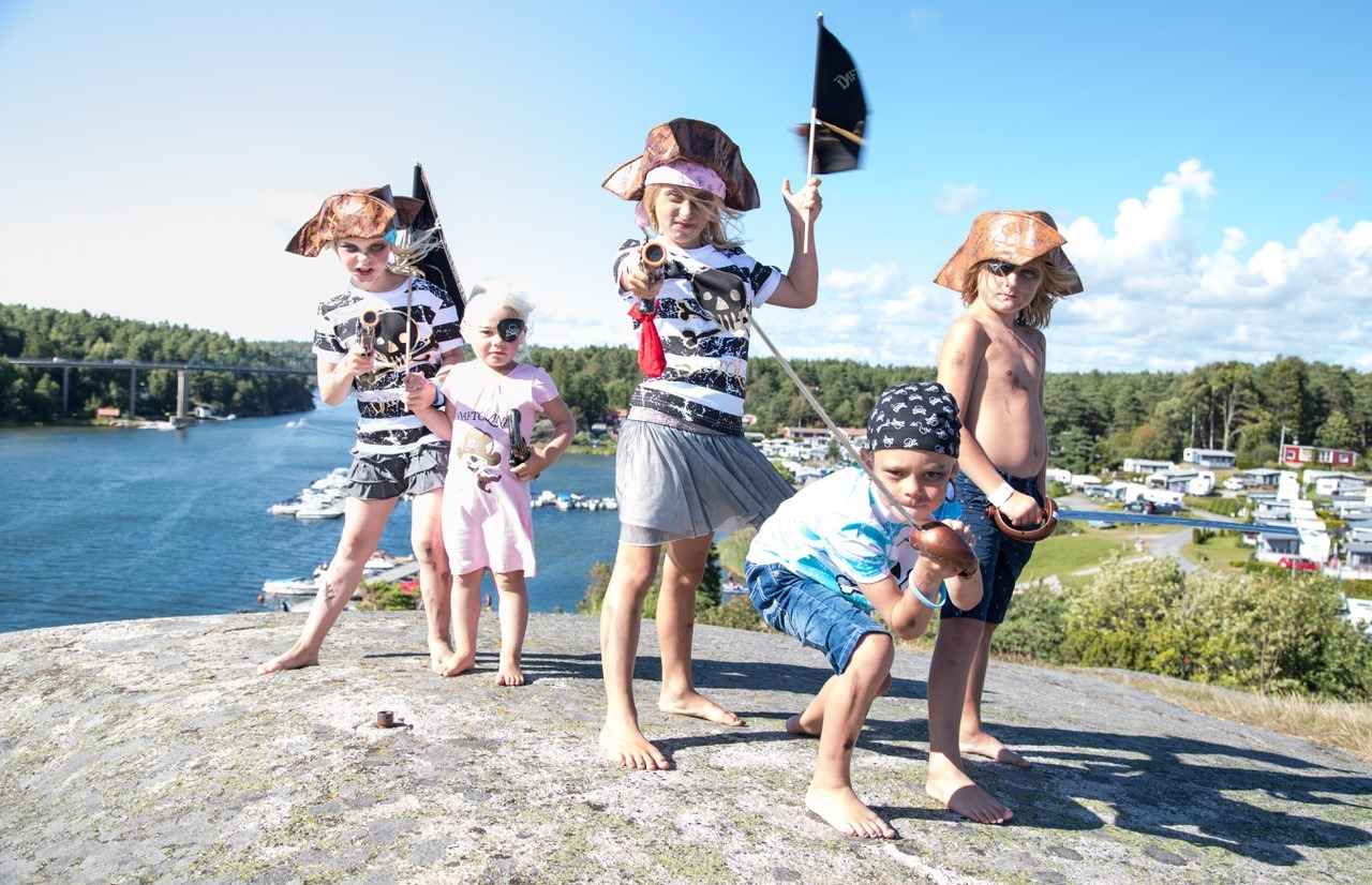 Five children dressed as pirates are posing for the camera.