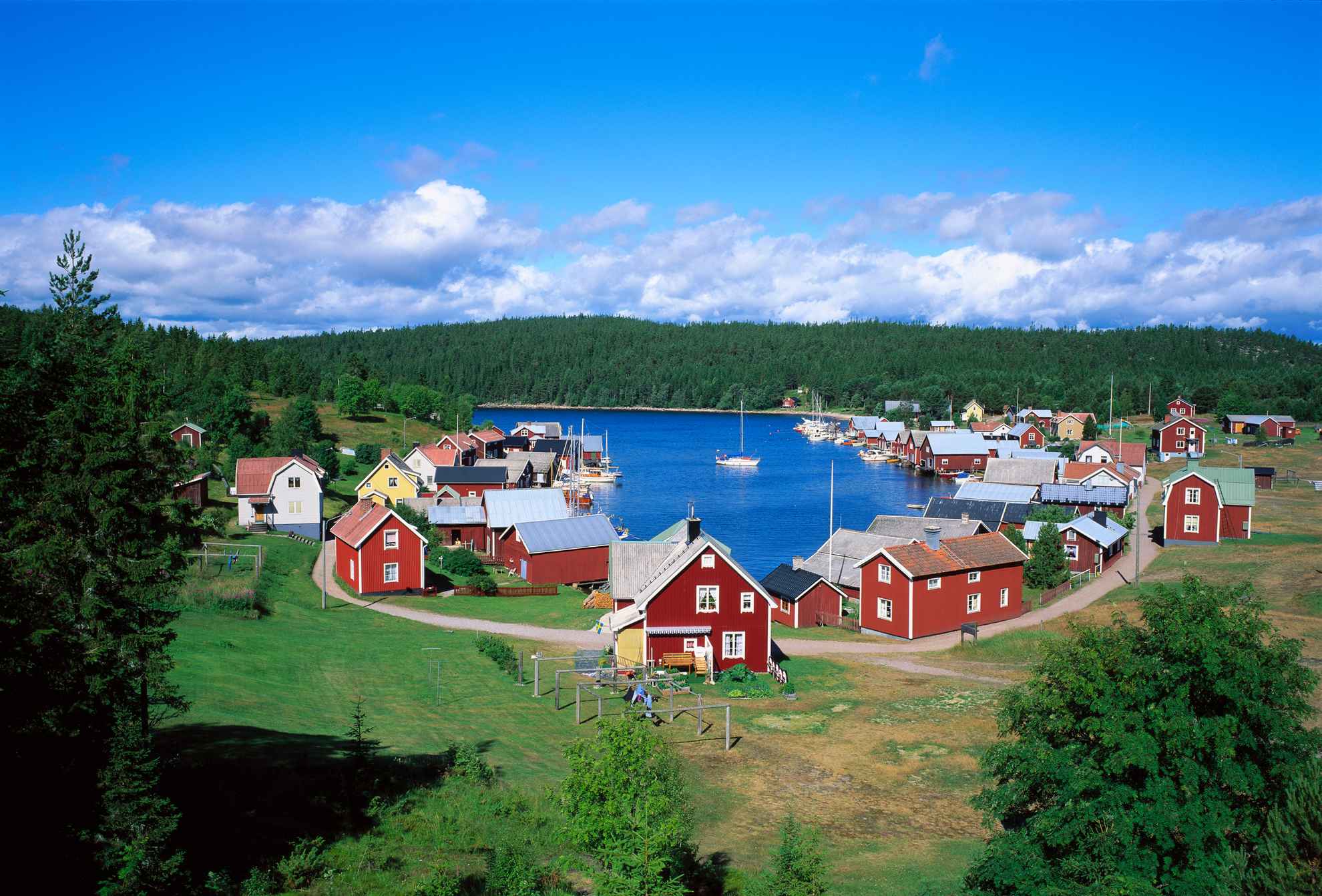 The bay with mostly red cabins at Trysunda Island on a sunny summer day.