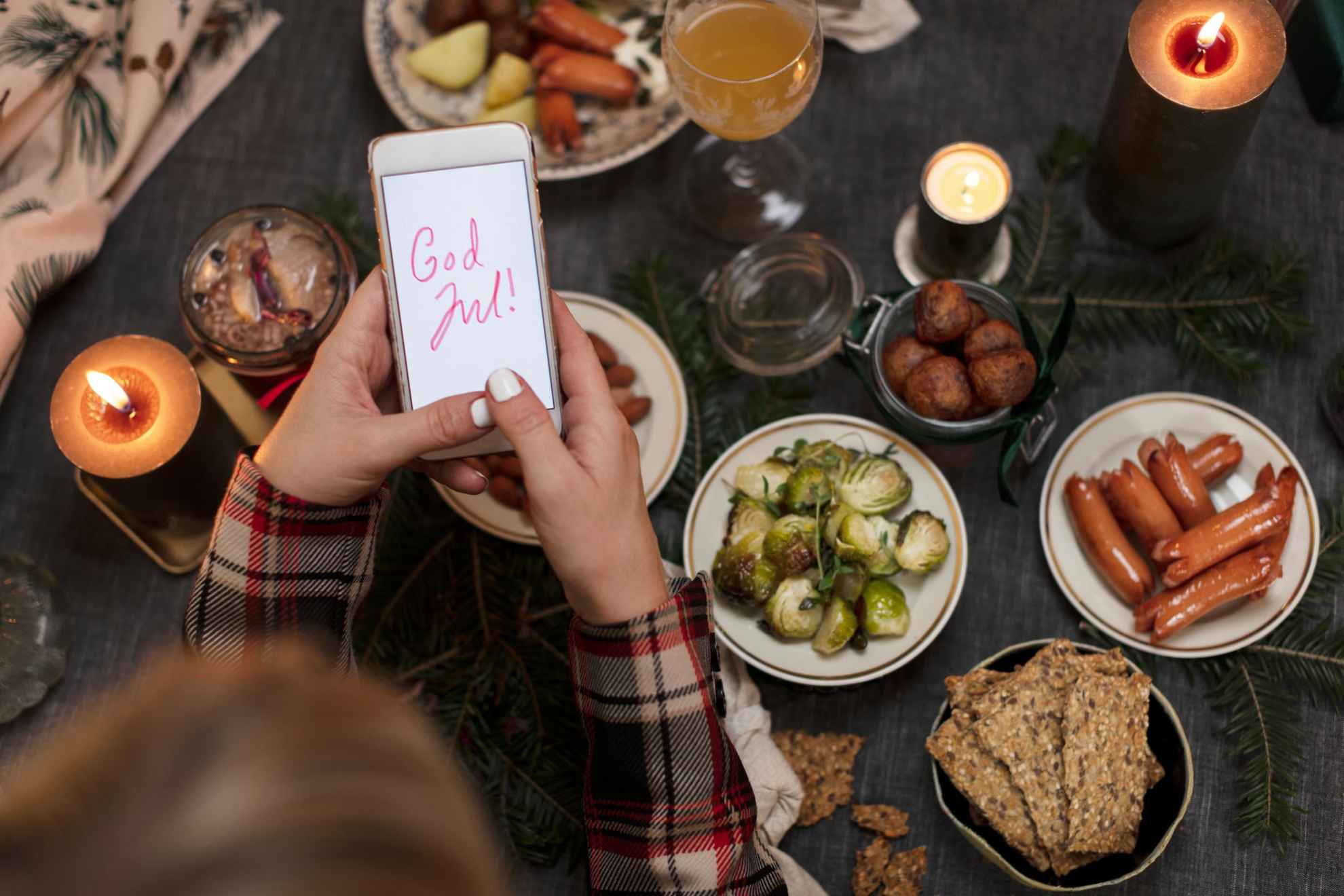 Someone holds up a phone to a traditional Christmas smorgasbord.