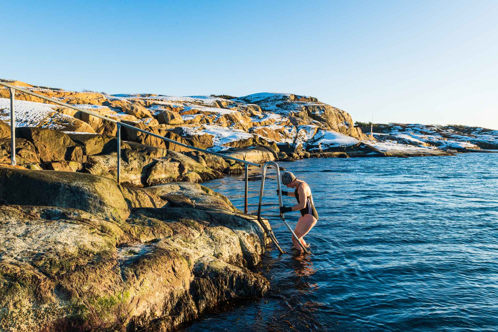 A woman is bathing in the sea during winter.