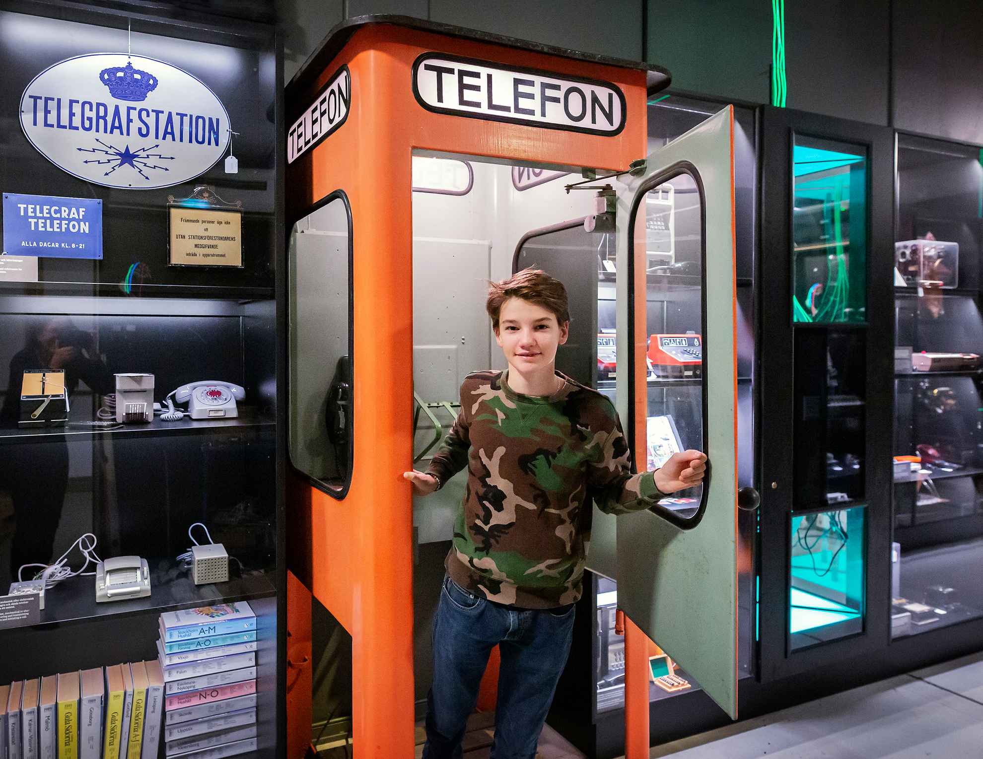 Young boy in a phone booth at the National Museum of Science and Technology.