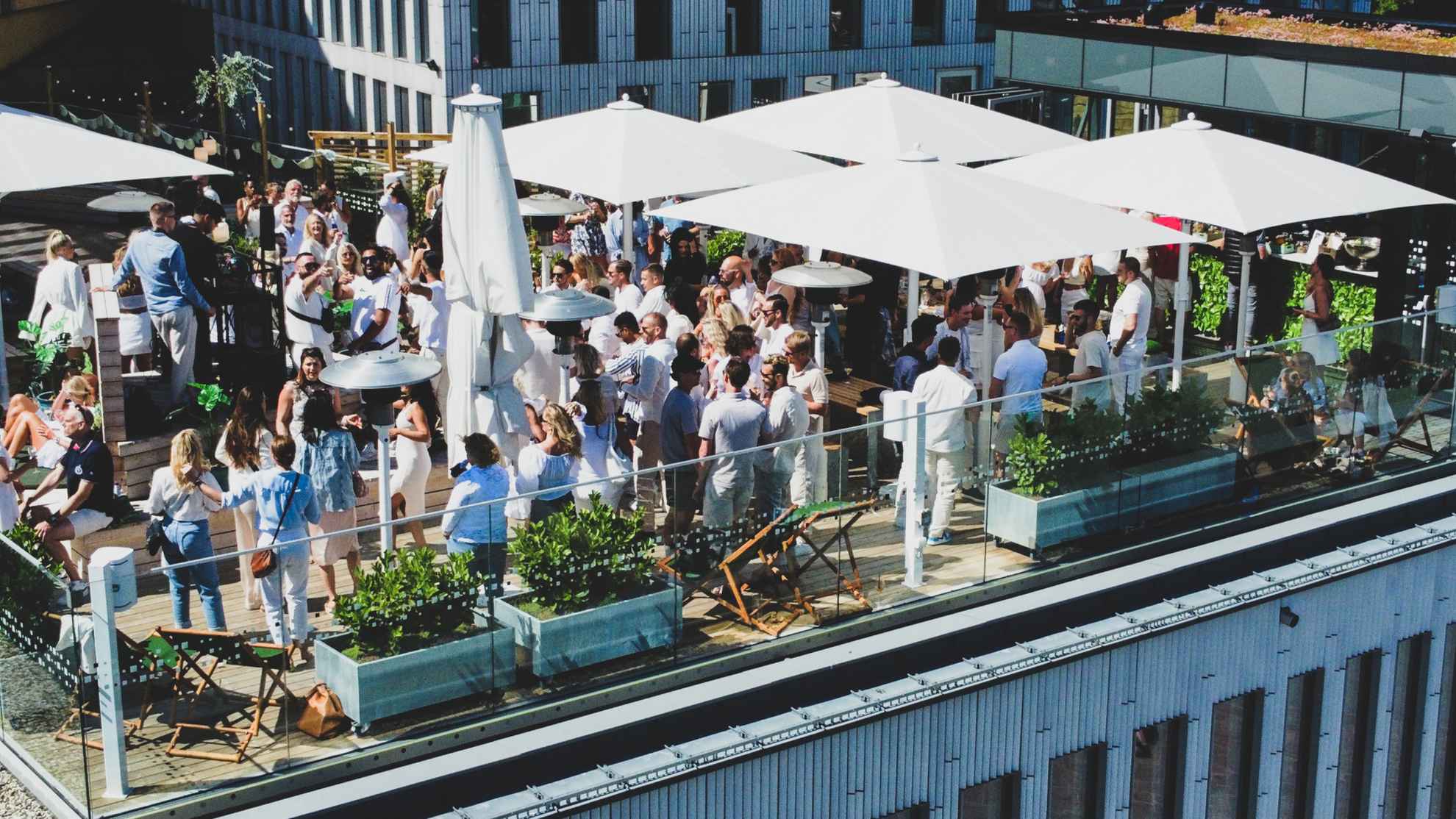 People drinking cocktails on a rooftop bar.