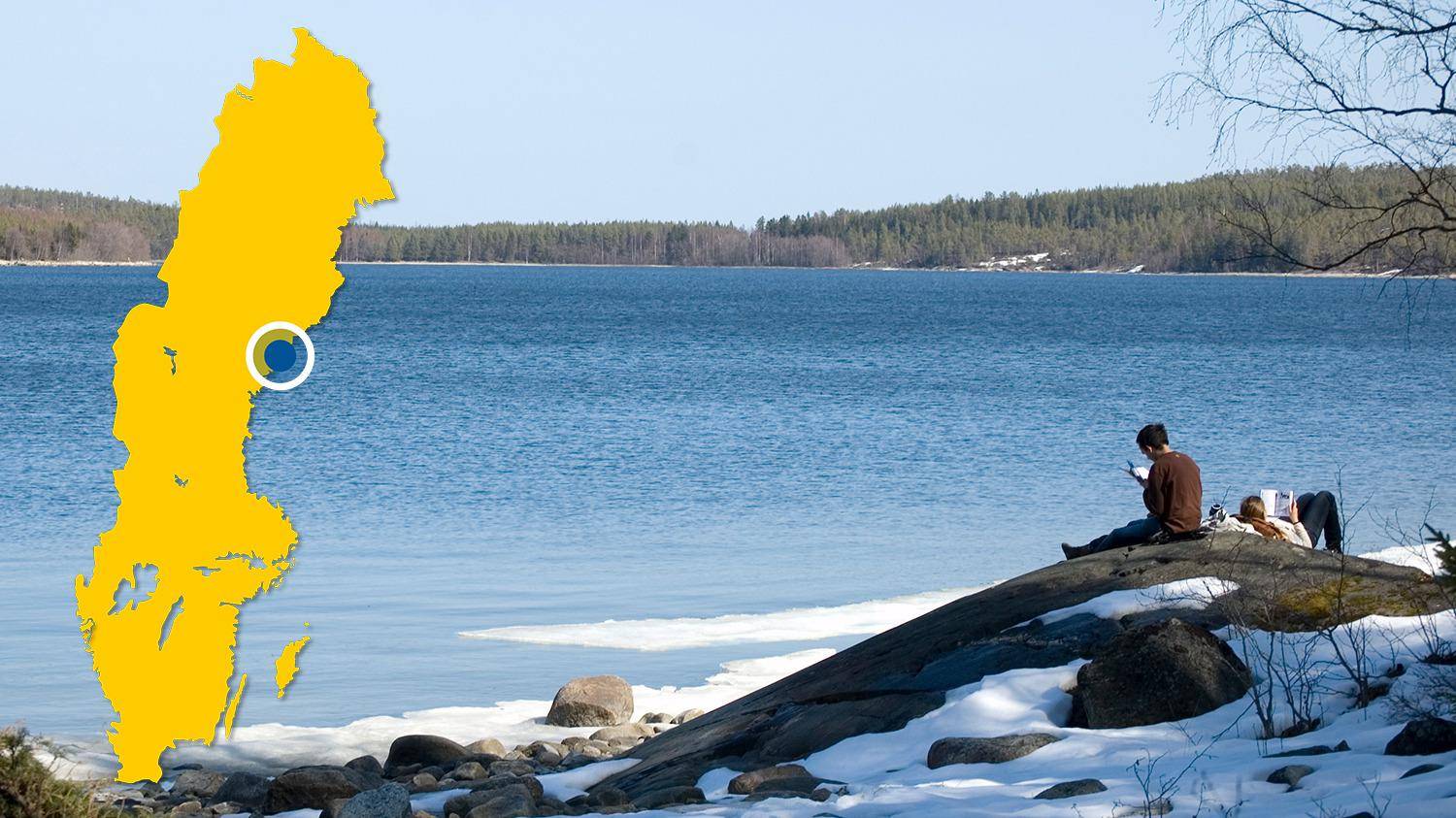 Two people sitting on a cliff near the water and reading books in the sun during the winter. There is a yellow map of Sweden with a blue dot that marks the location of Bodviken.