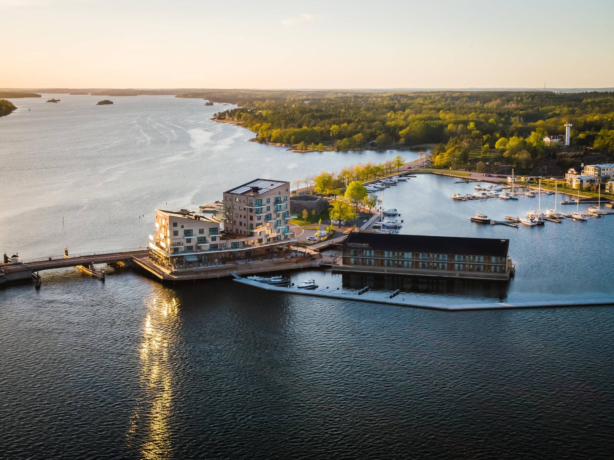 Aerial view of the hotel Slottsholmen and its large terrace, surrounded by water and located by a small harbour.