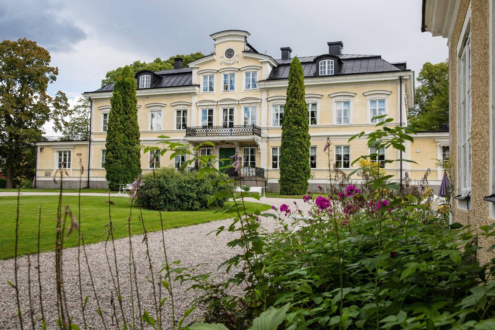 The building of Färna manor surrounded by greenery during a summer day.