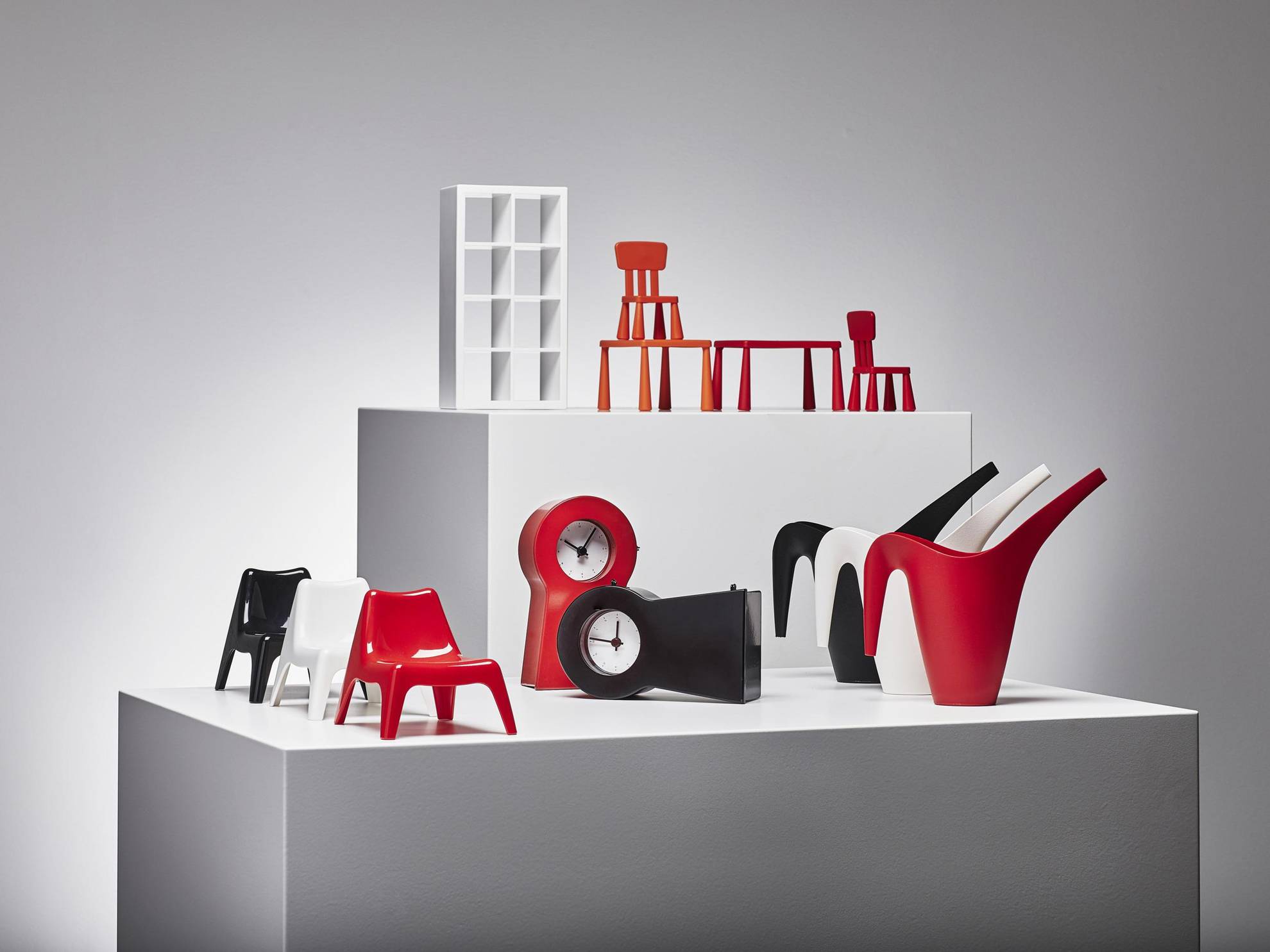 Small plastic stools and tables, watches and watering pots displayed on a white area.