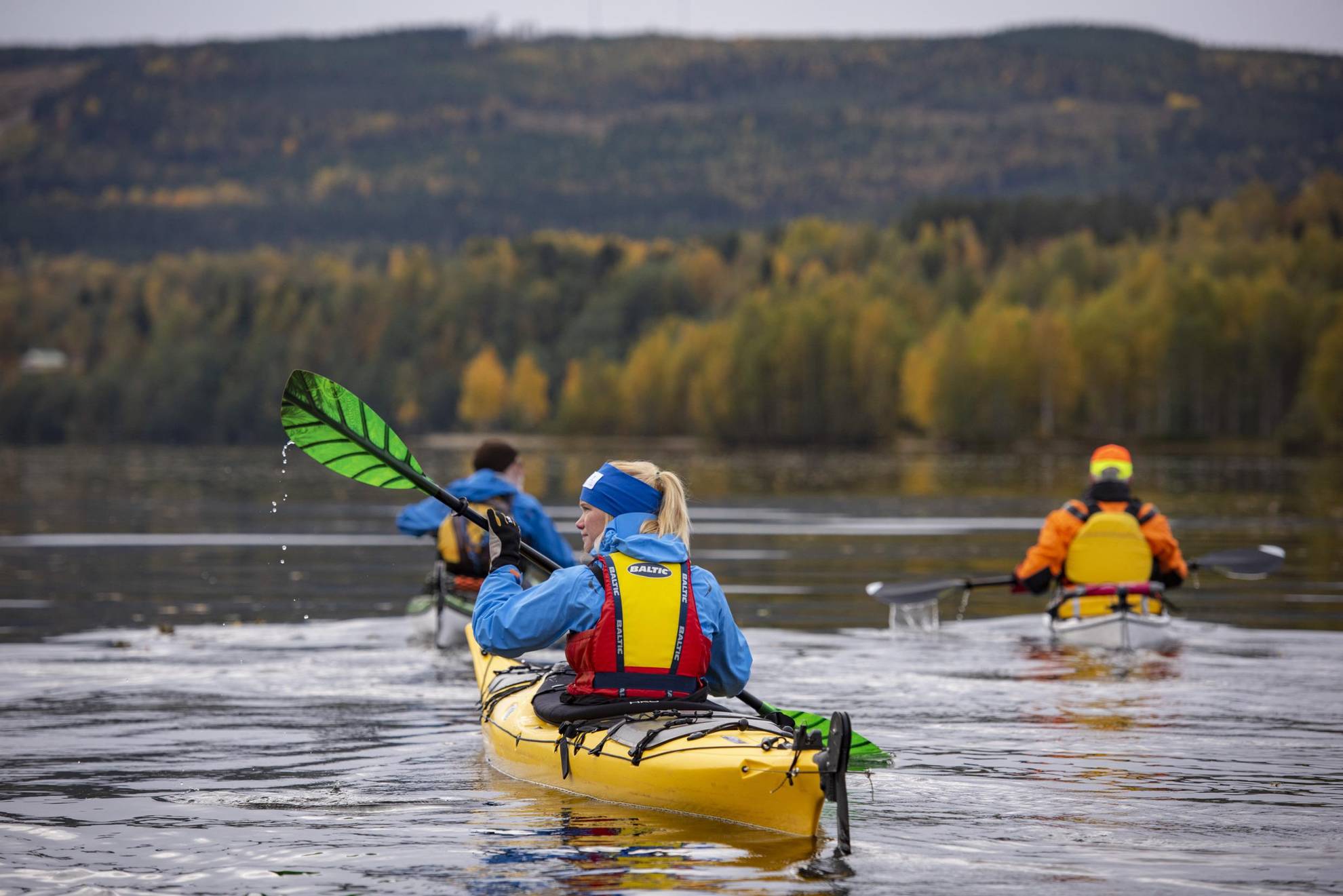 A women paddling a kayak in a group.