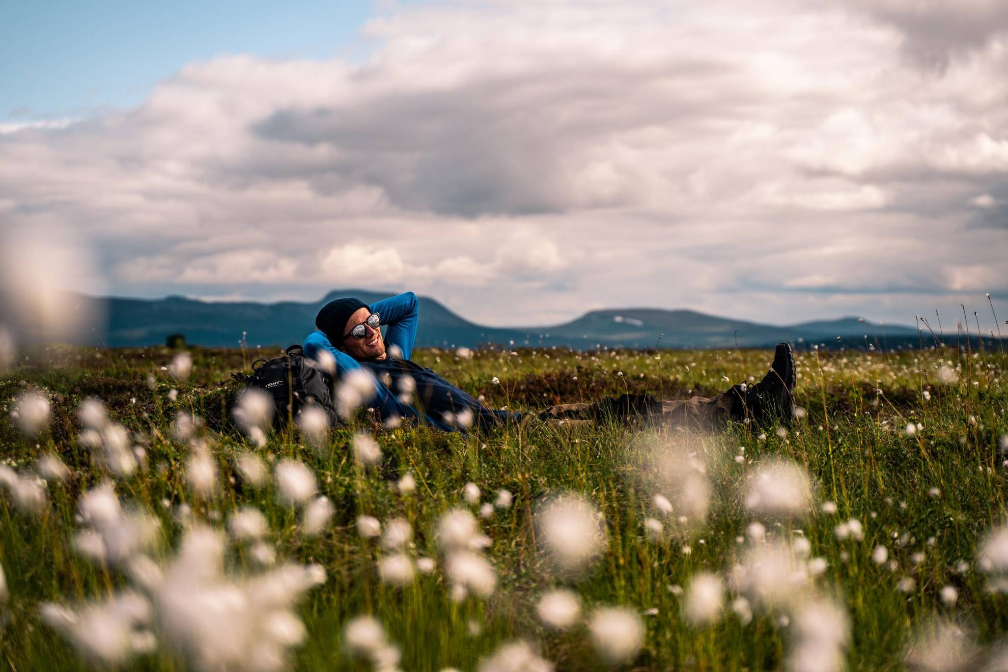 A man is relaxing in a meadow during the summer.