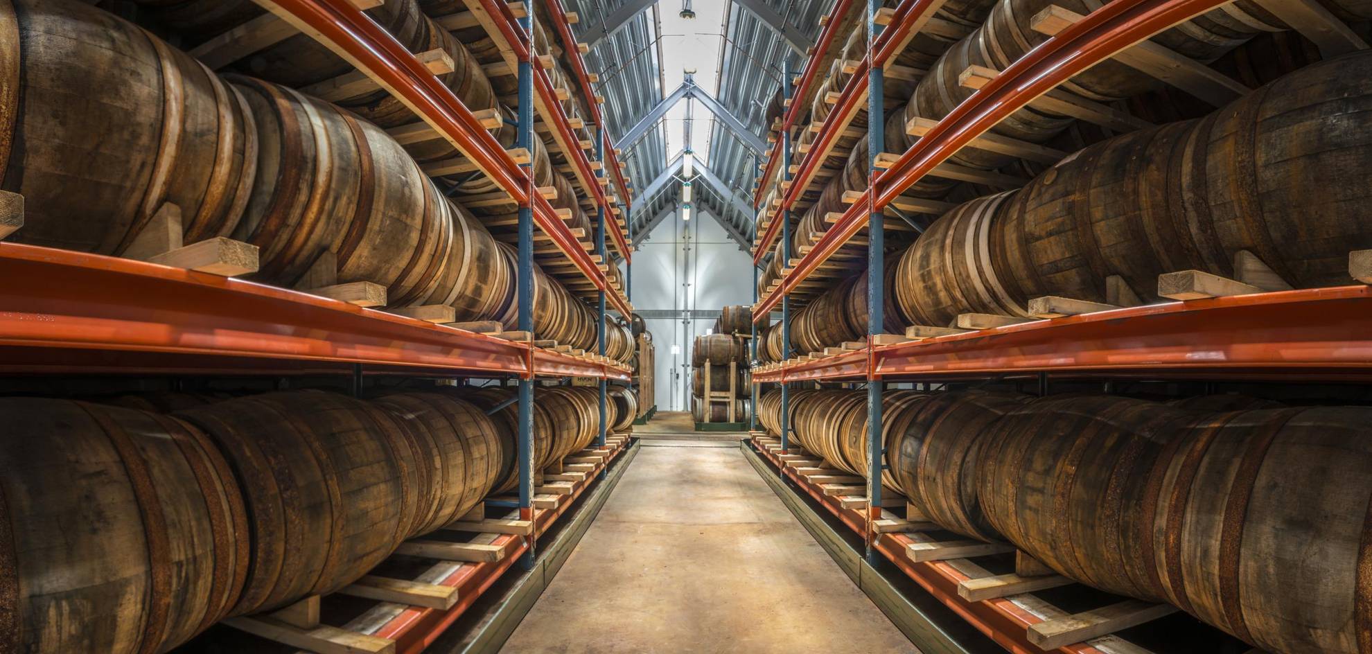 An aisle with barrels of distilled spirits on both sides at the distillery Spirit of Hven.