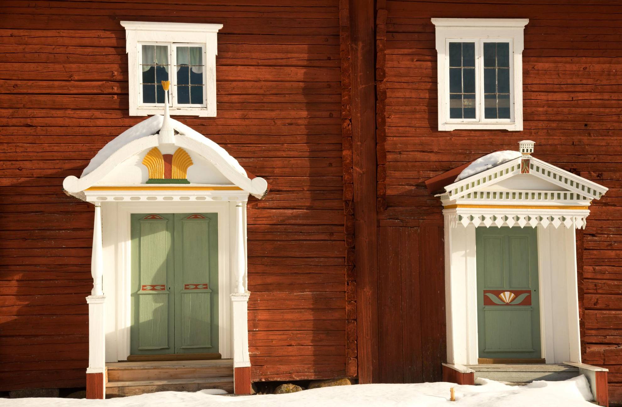 A close-up of a traditional farm house in Hälsingland province with wooden ornaments decorating the entrances.