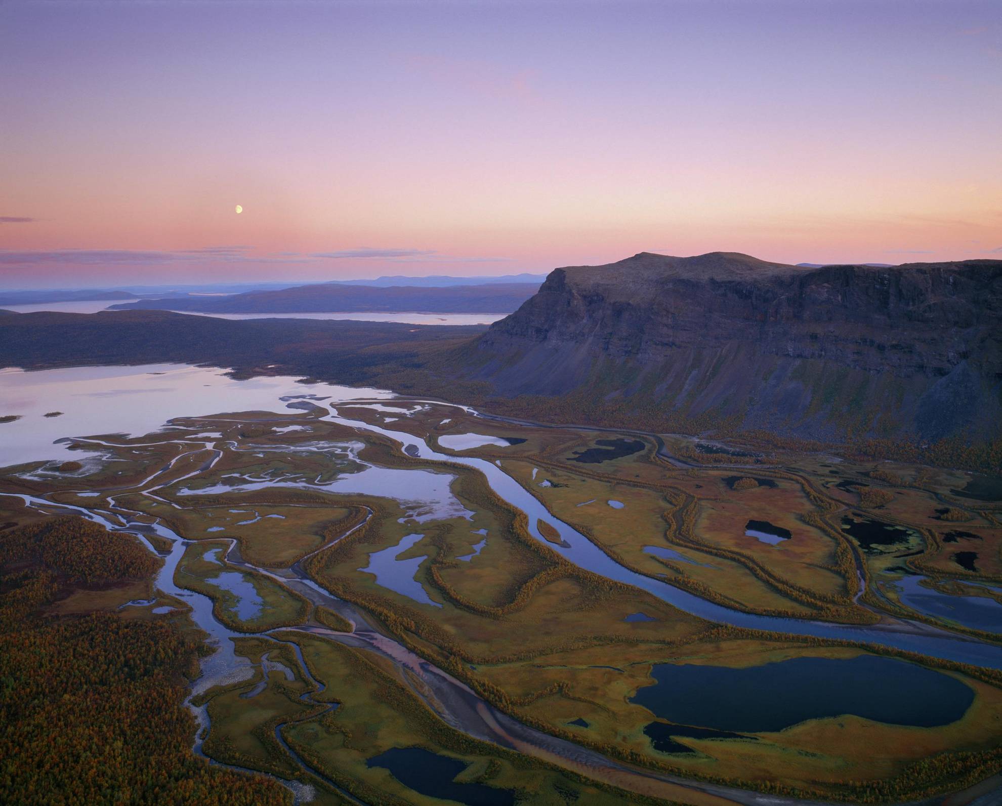 Aerial view of Rapadalen valley and the surrounding mountains of Sarek National Park during twilight.
