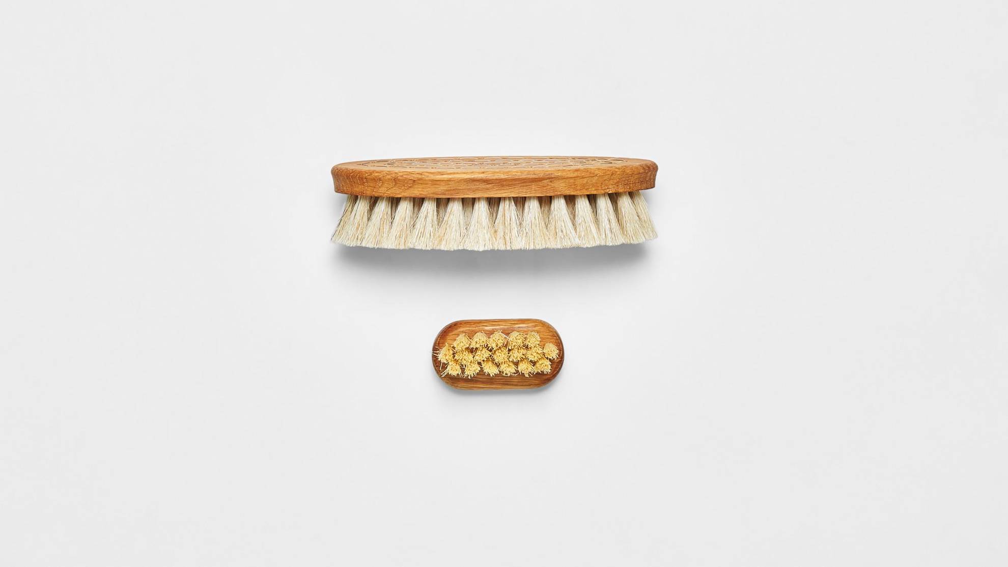 A wooden bath brush on a white surface.