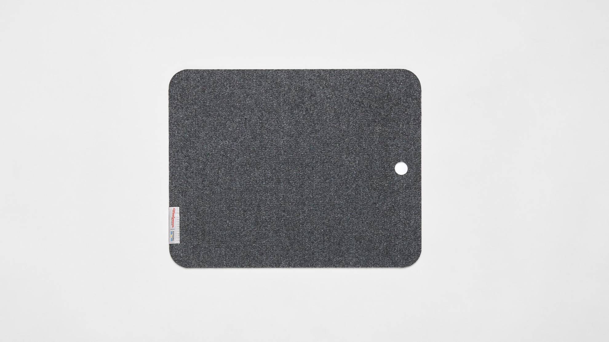 A dark grey sit pad on a white surface.