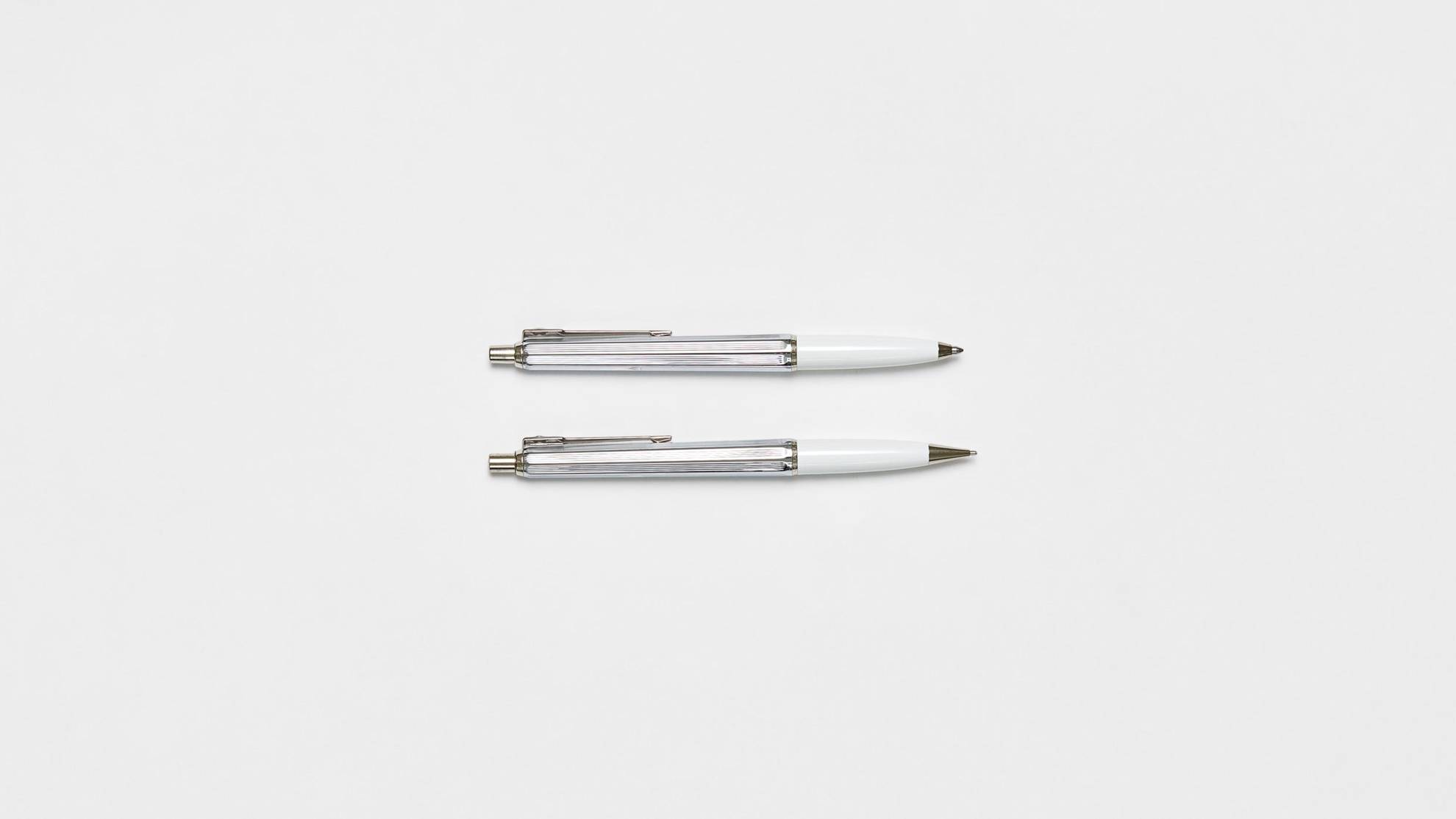 Two ballograf pencils on a white surface.