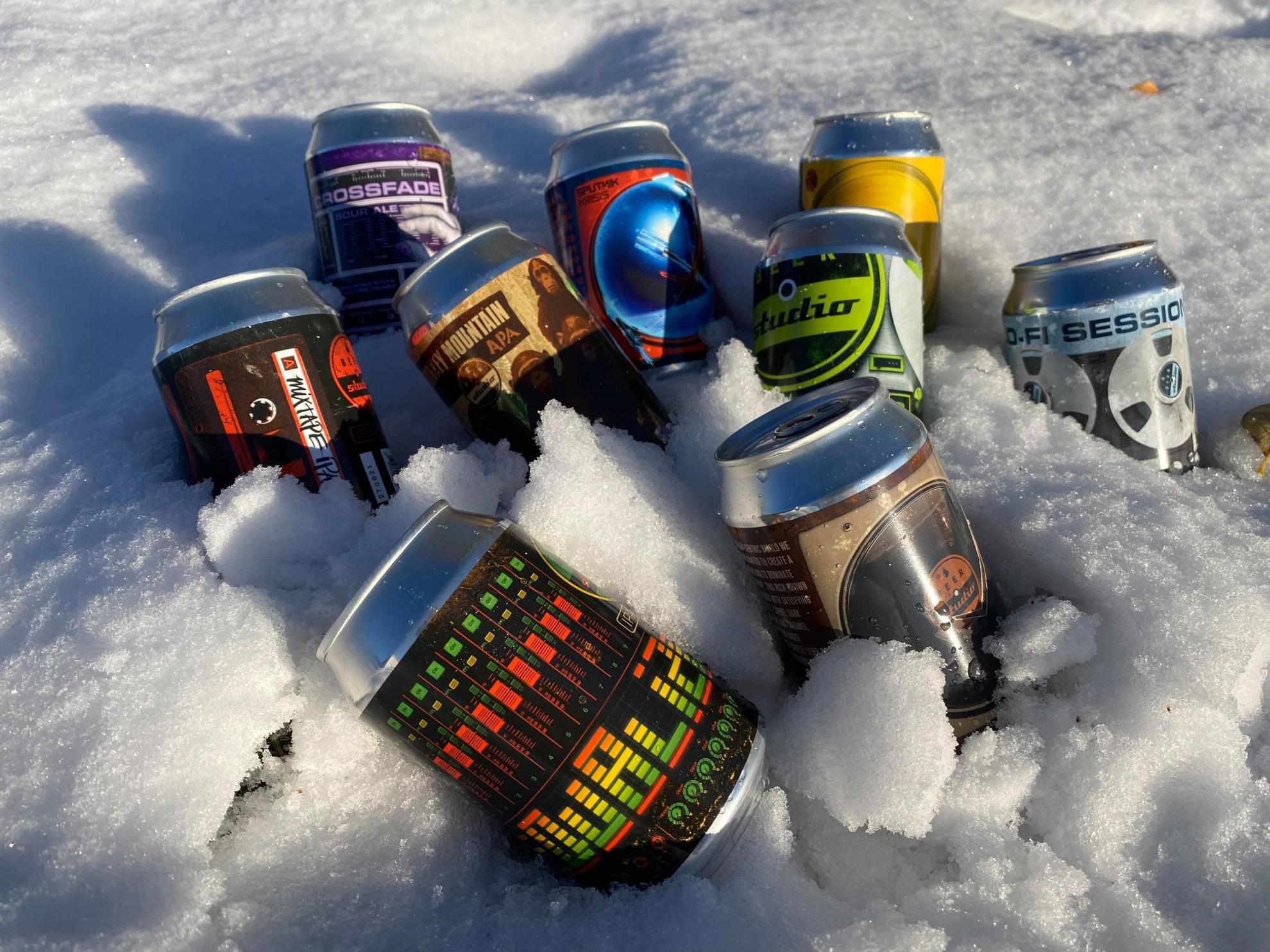 A selection of beers being cooled down in the snow.