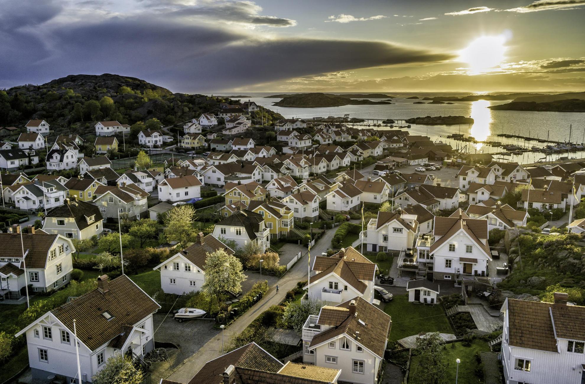 Suburban white houses with tiled roofs overlook the ocean in Bihuslän.