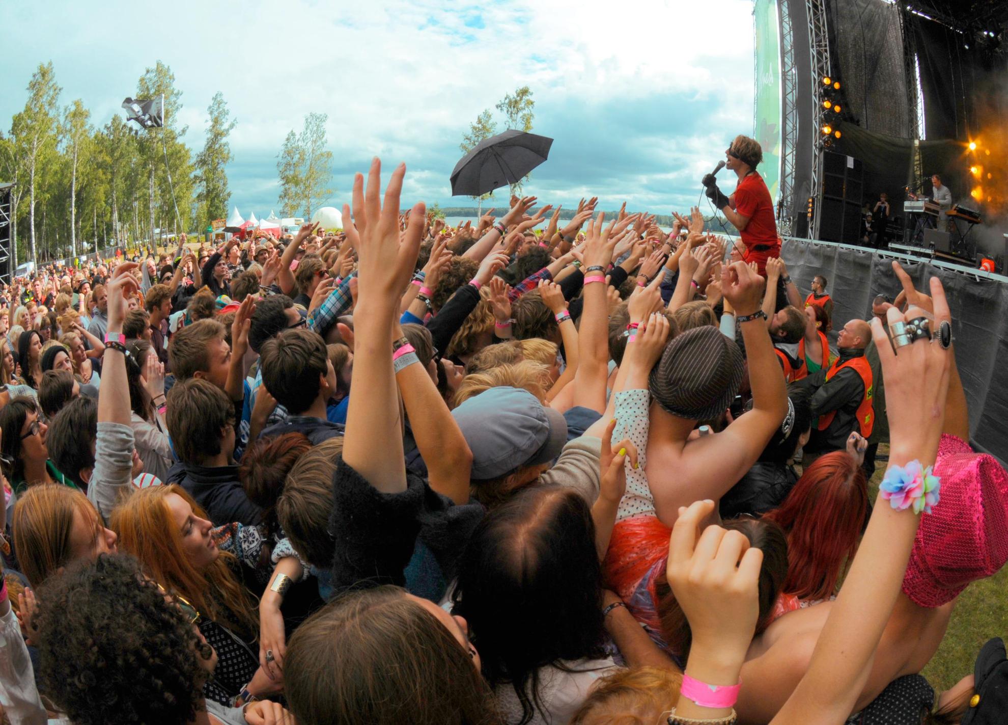 People in the audience raise their hands into the air during a Bob Hund concert at a Swedish festival.