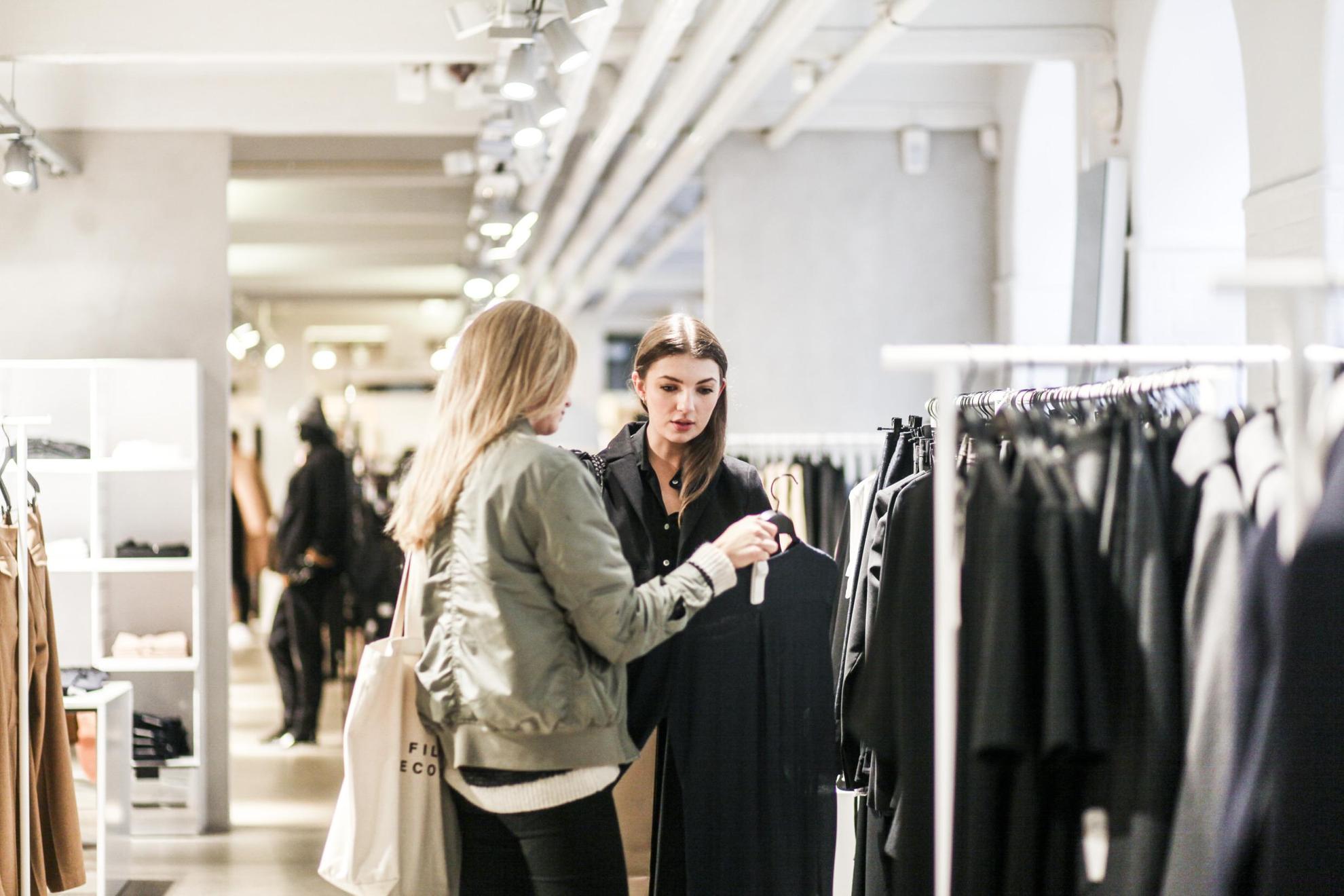 Two women in a Stockholm store are looking at a dress.