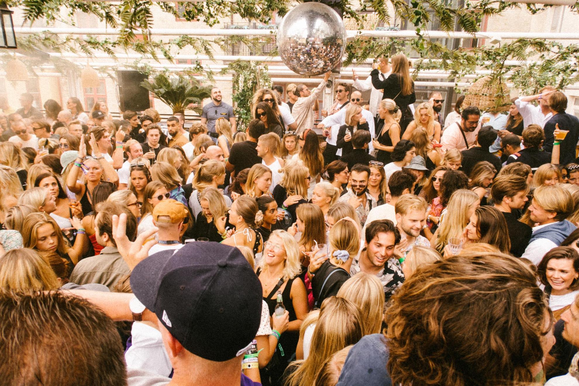 People dancing at a rooftop club during the summer.