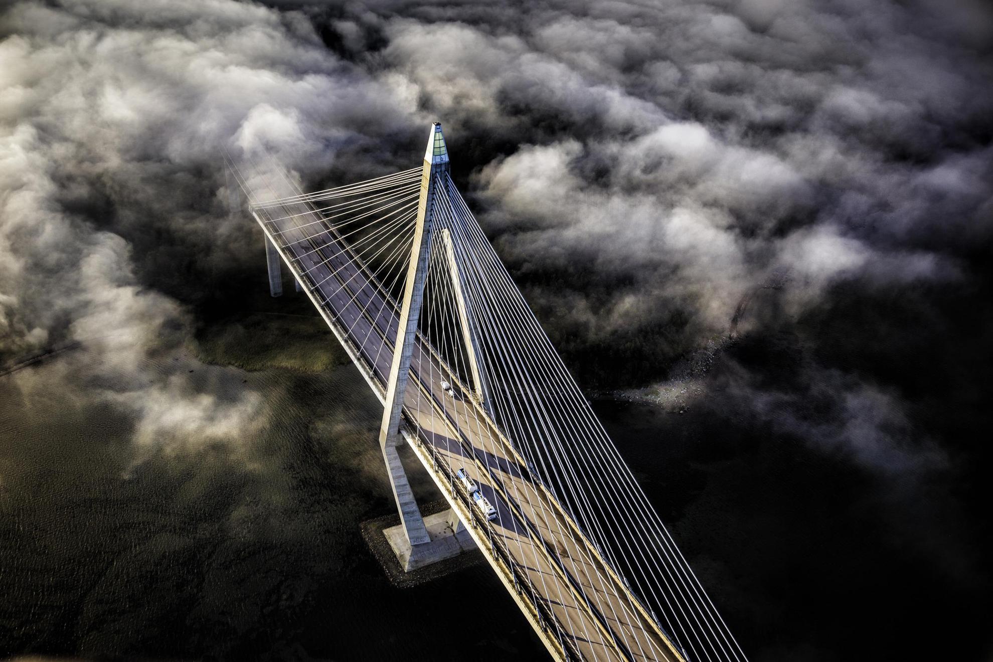 A view from above of the Uddevalla Bridge in fog. There is traffic on the bridge and water underneath.