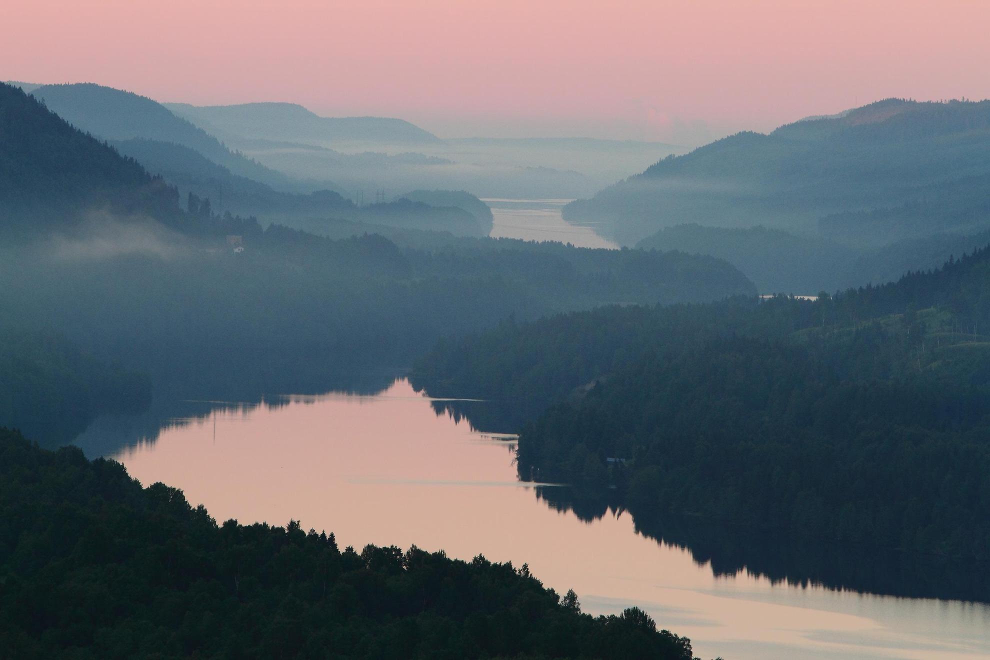View of the Indalsälven at dusk. The fog is low and the sky is dusky pink.