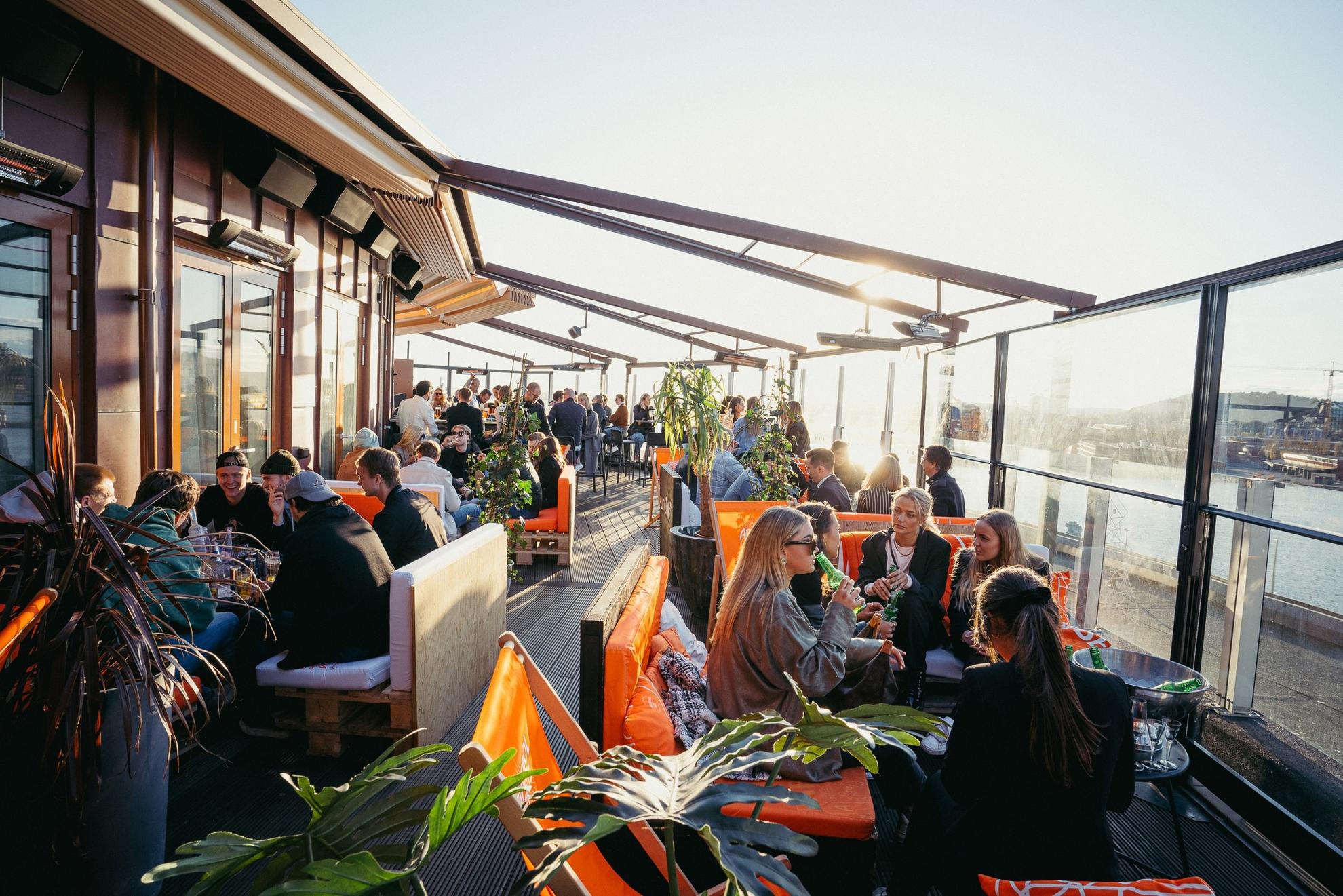People sit and enjoy drinks and the company of friends at the rooftop Taket in Gothenburg.