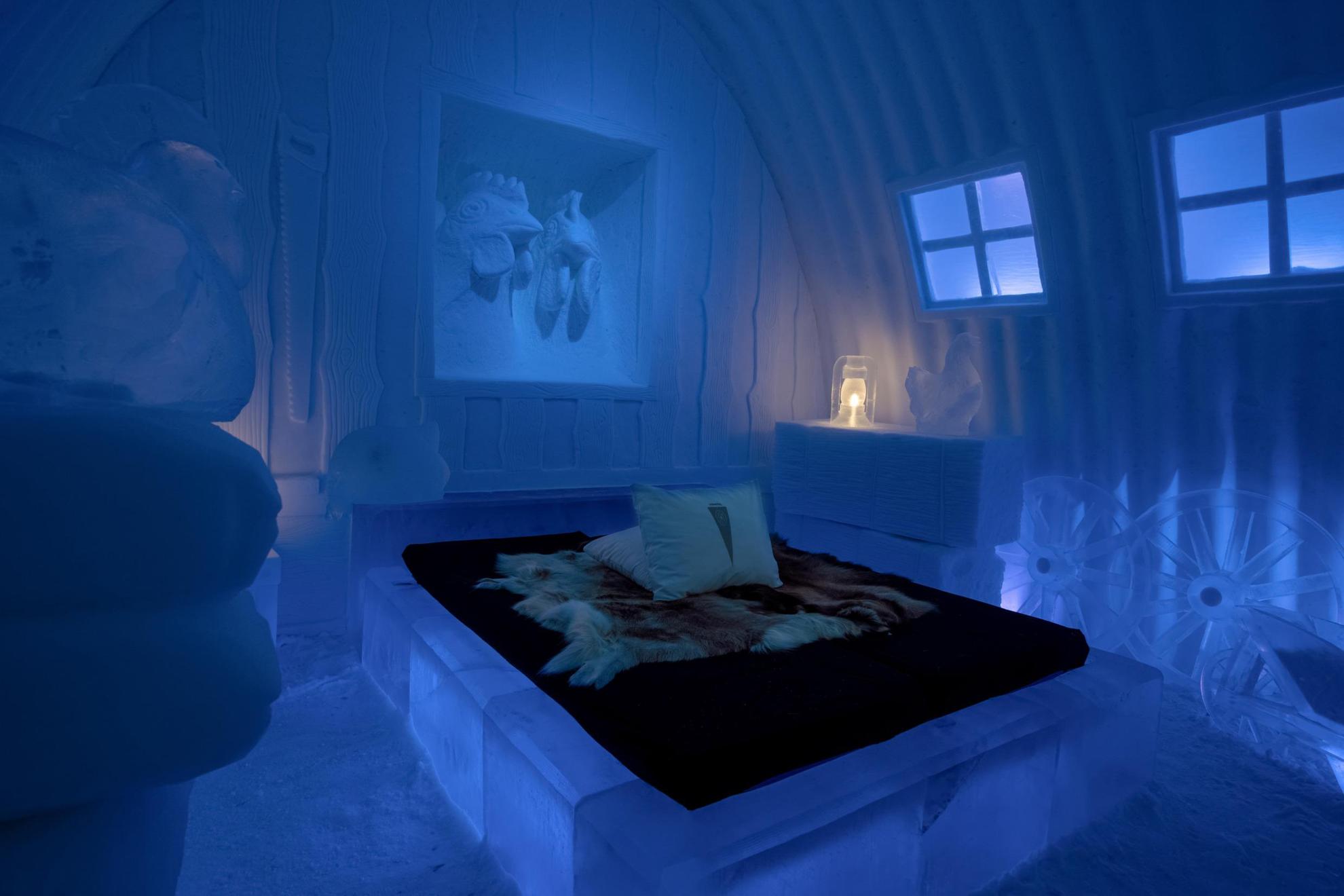 A hotel room made out of ice. Sculptures of chickens made out of ice and snow decorates the room.
