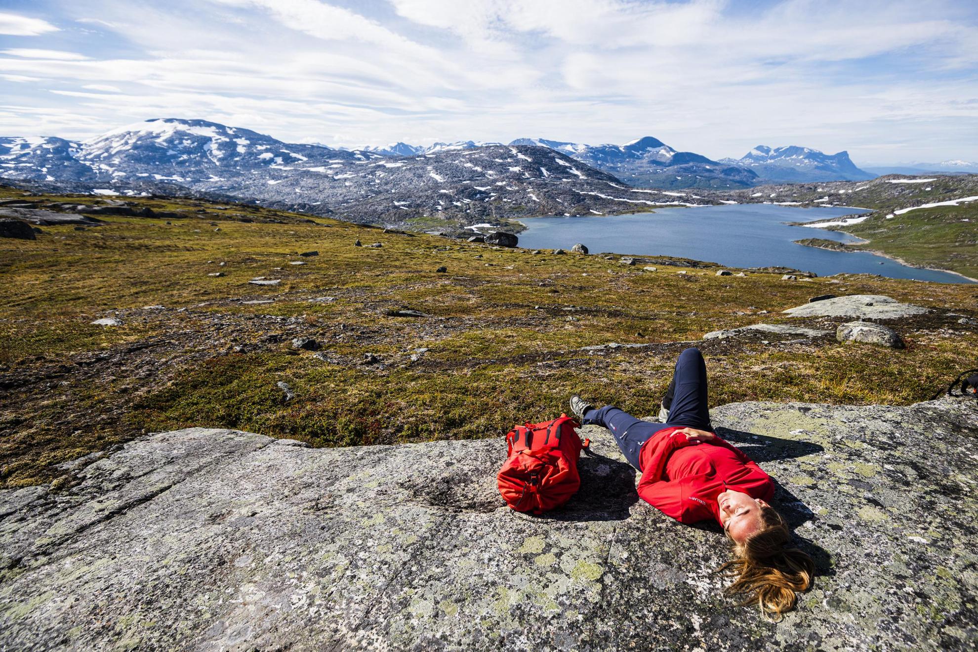 A woman laying down relaxing. The view of Abisko mountain in the background.