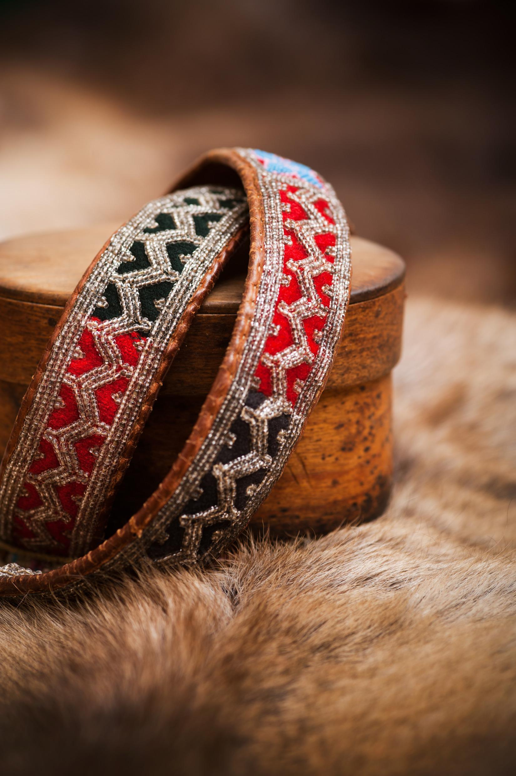 Sami handcraft leather and pewter bracelets on a reindeer pelt.